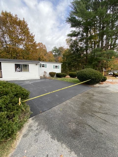 Suburban house with a paved driveway and yellow caution tape blocking the entrance
