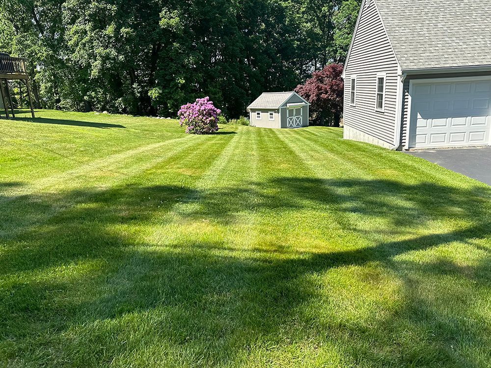 A garden bed with flowers and gravel in front of a house.