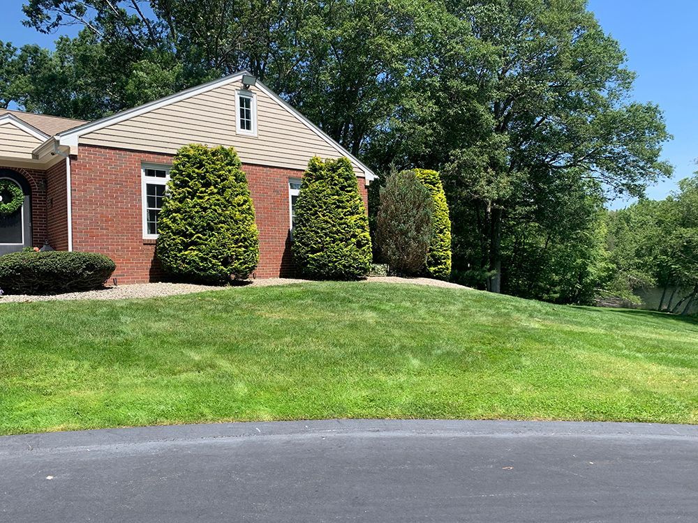 A brick house with a lush green lawn in front of it.