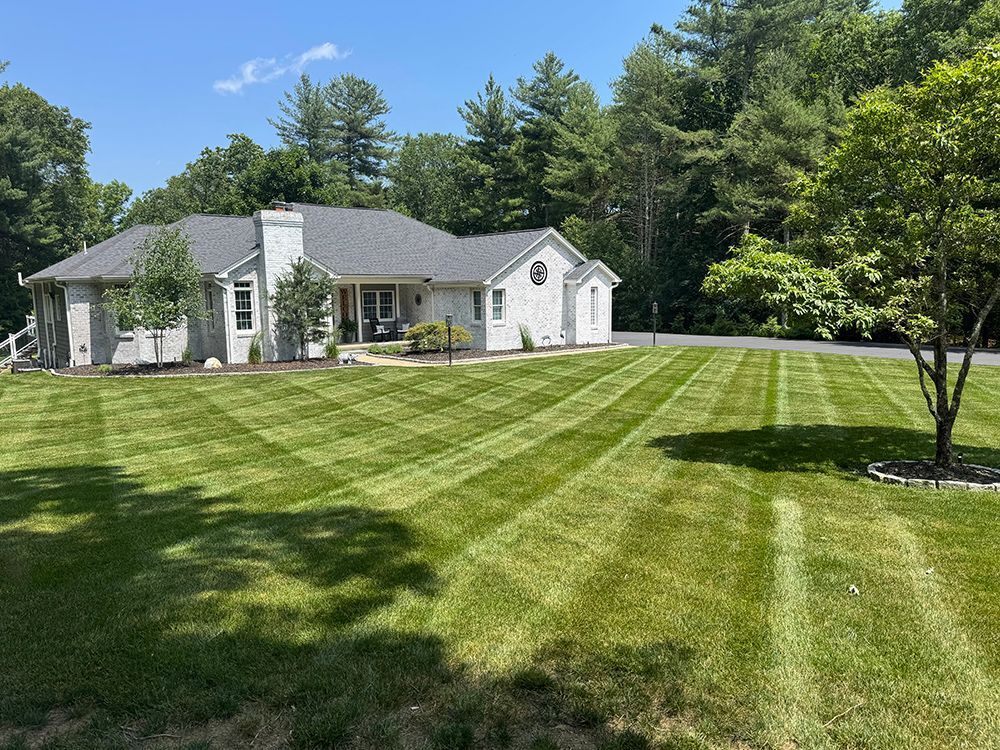 A large white house with a lush green lawn in front of it.