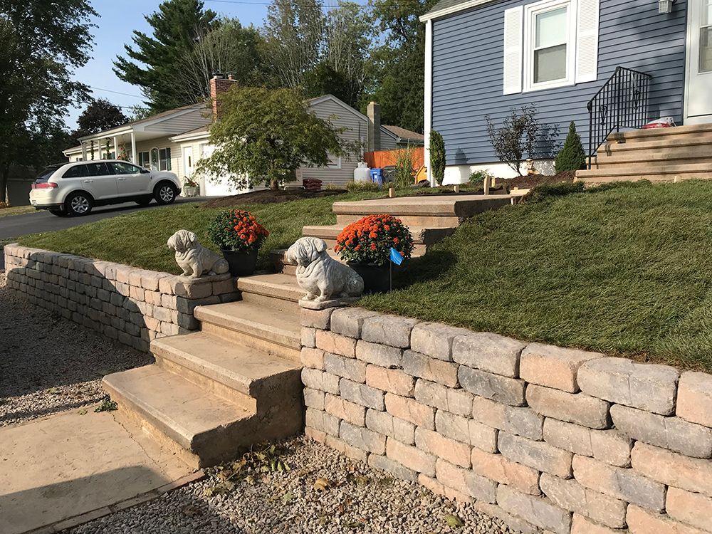 A brick wall with stairs leading up to a house.