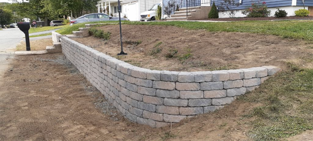 A brick wall is being built in front of a house.