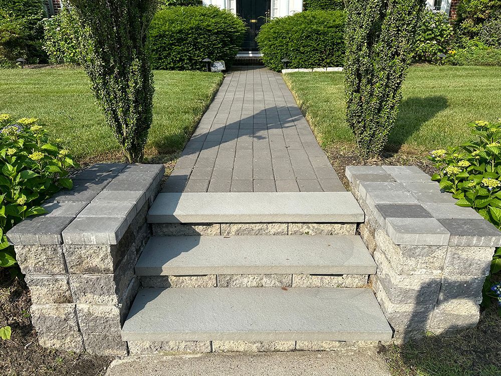A stone walkway with steps leading up to a house.