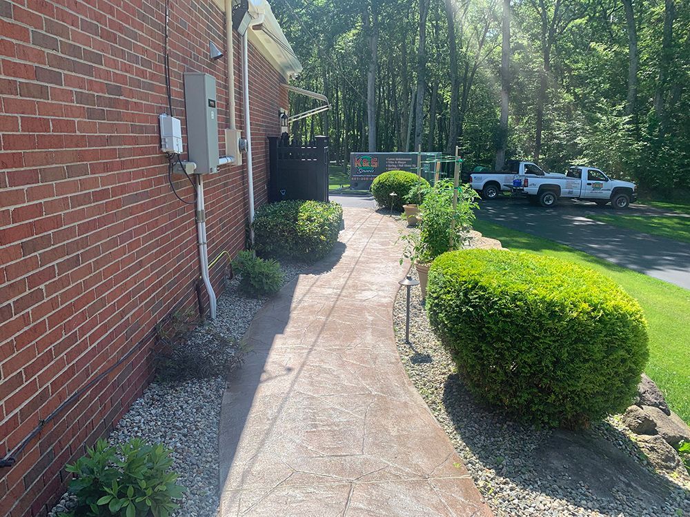 A brick building with a concrete walkway leading to it.