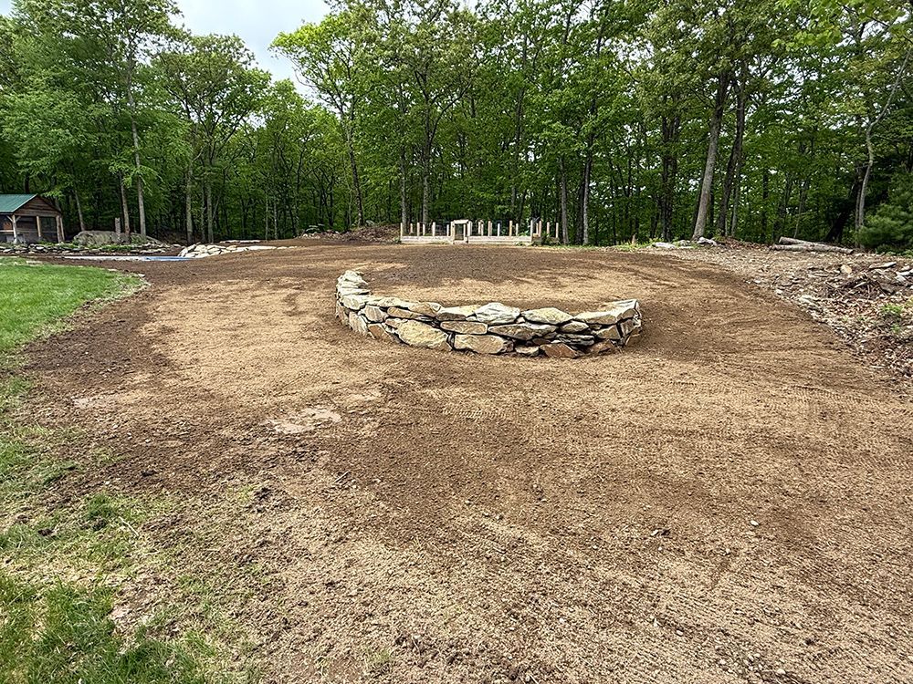 A dirt road with a stone wall in the middle of it.