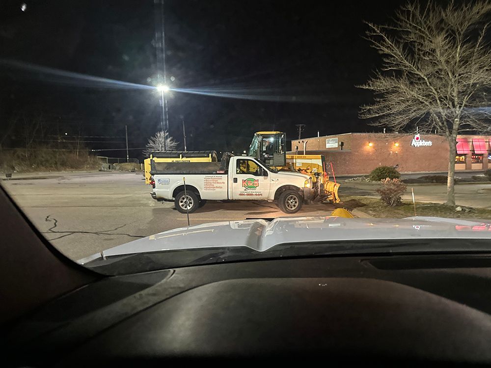 A truck is parked in a parking lot at night.