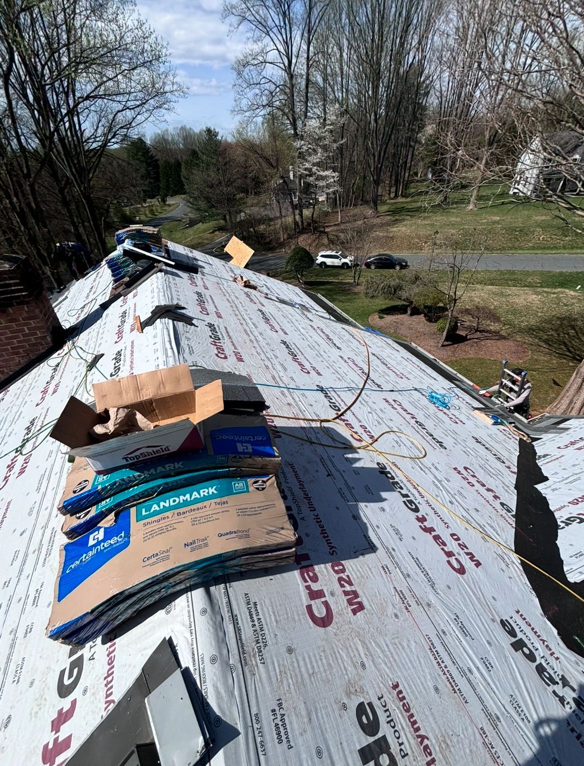 Roof under construction with shingles and cardboard materials.