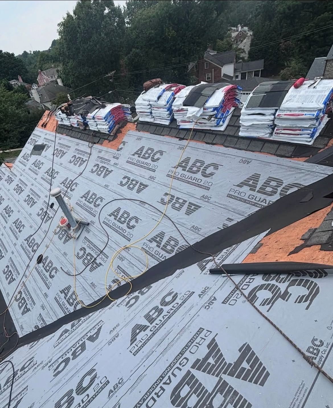 Roof with new underlayment and bundles of shingles, partially installed.