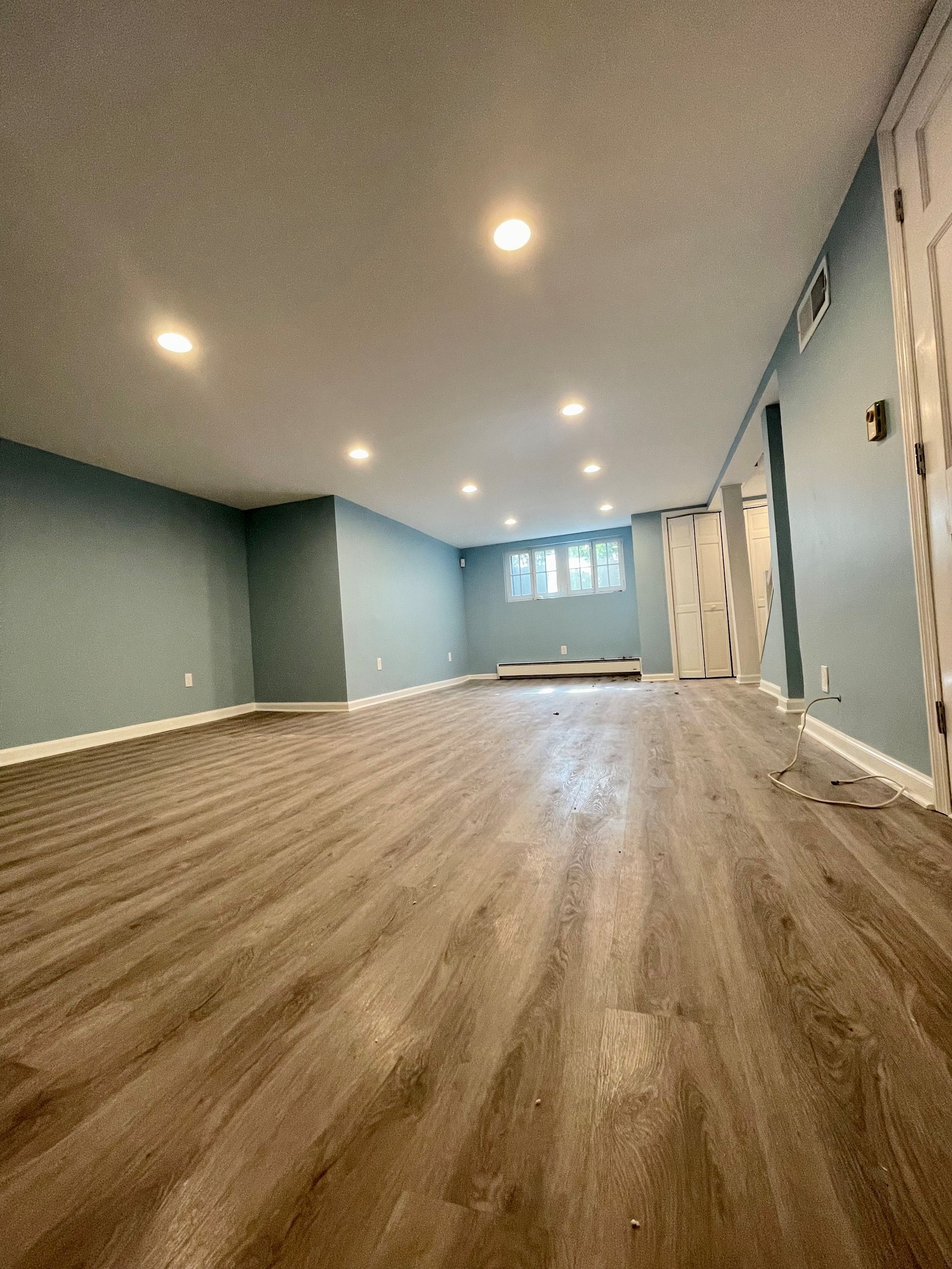 A large empty room with hardwood floors and blue walls.