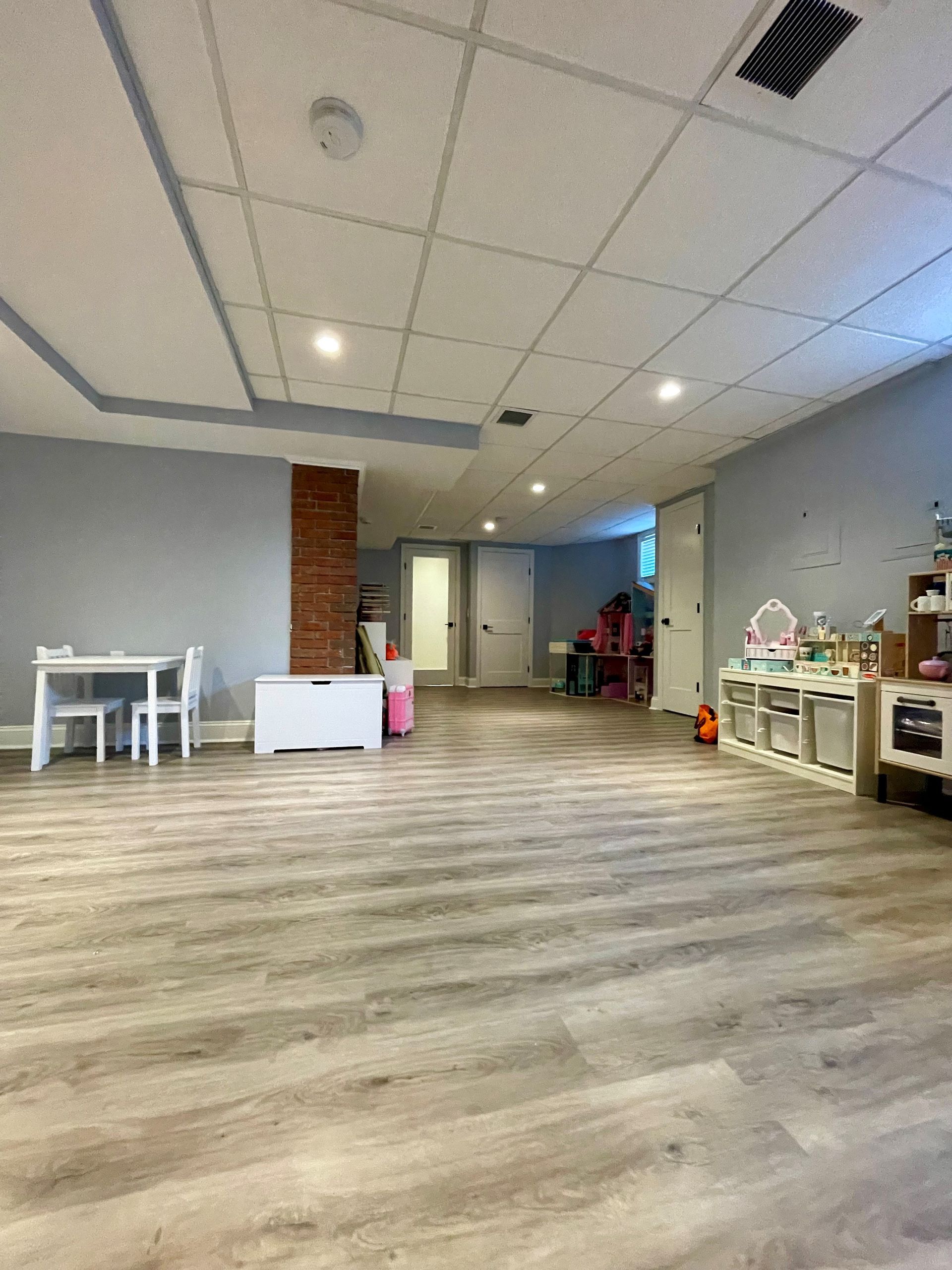 A large room with wooden floors and a table and chairs in it.
