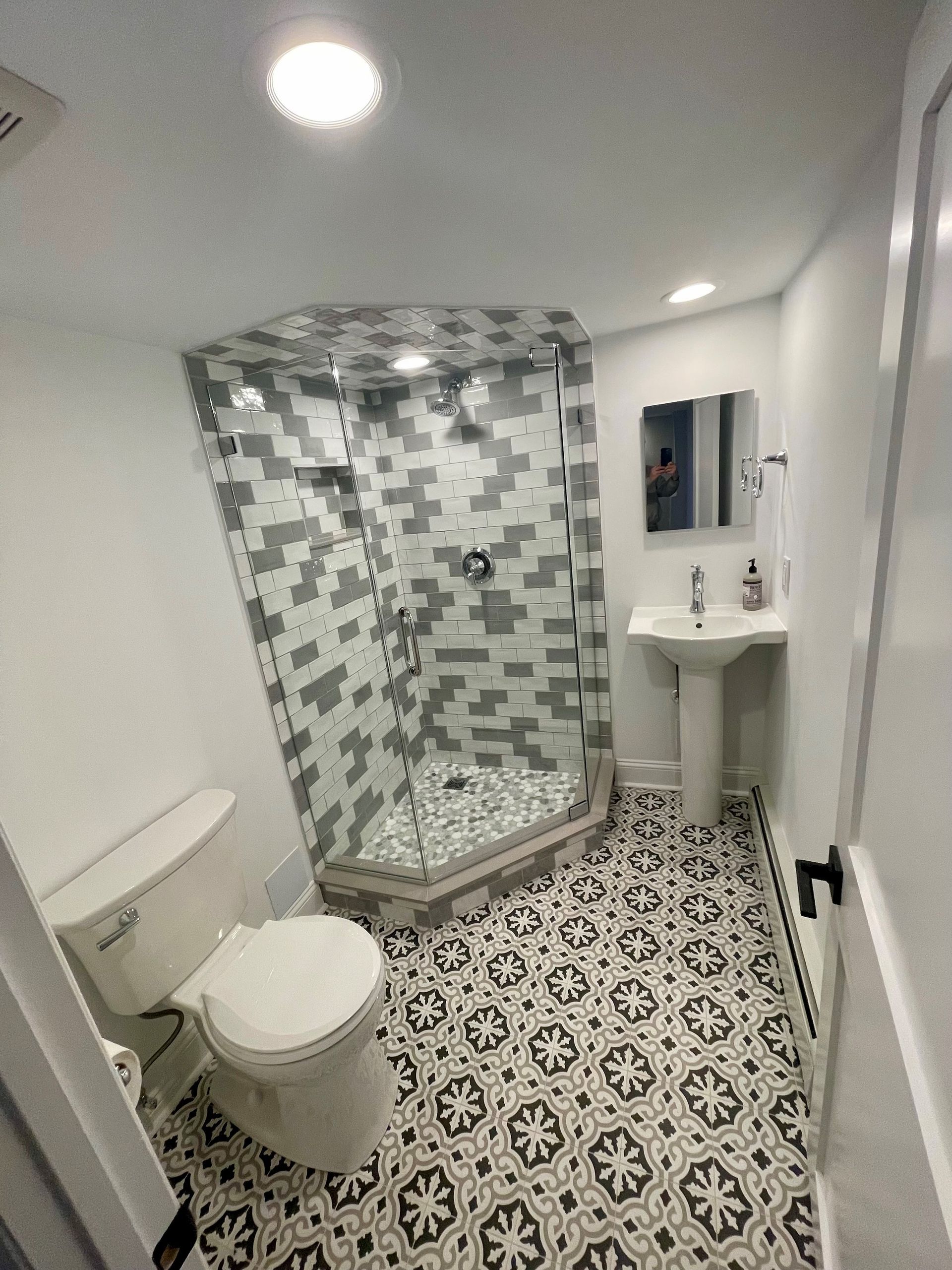 A bathroom with a toilet, sink, and shower.