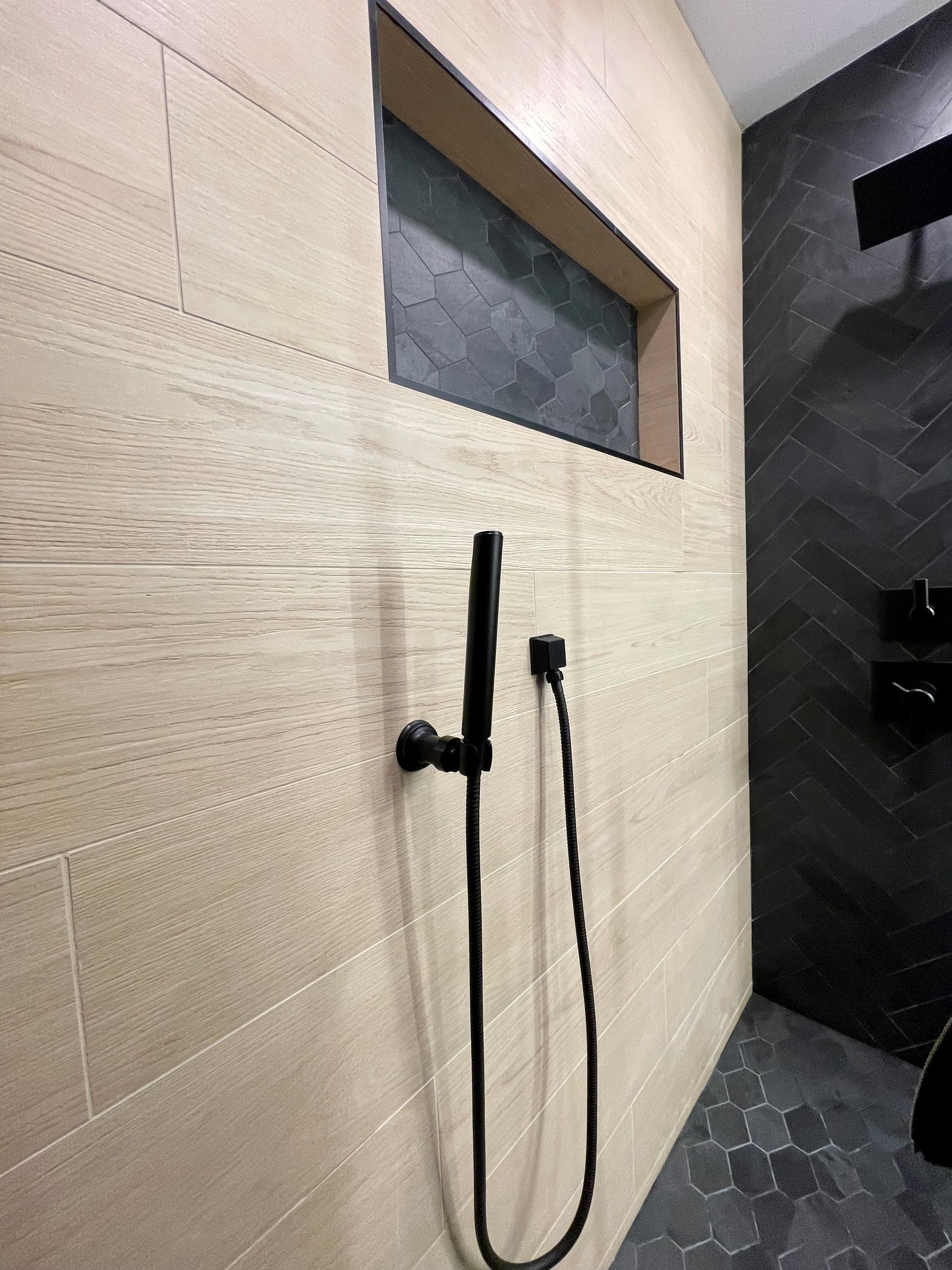 A shower head is hanging from the wall in a bathroom.