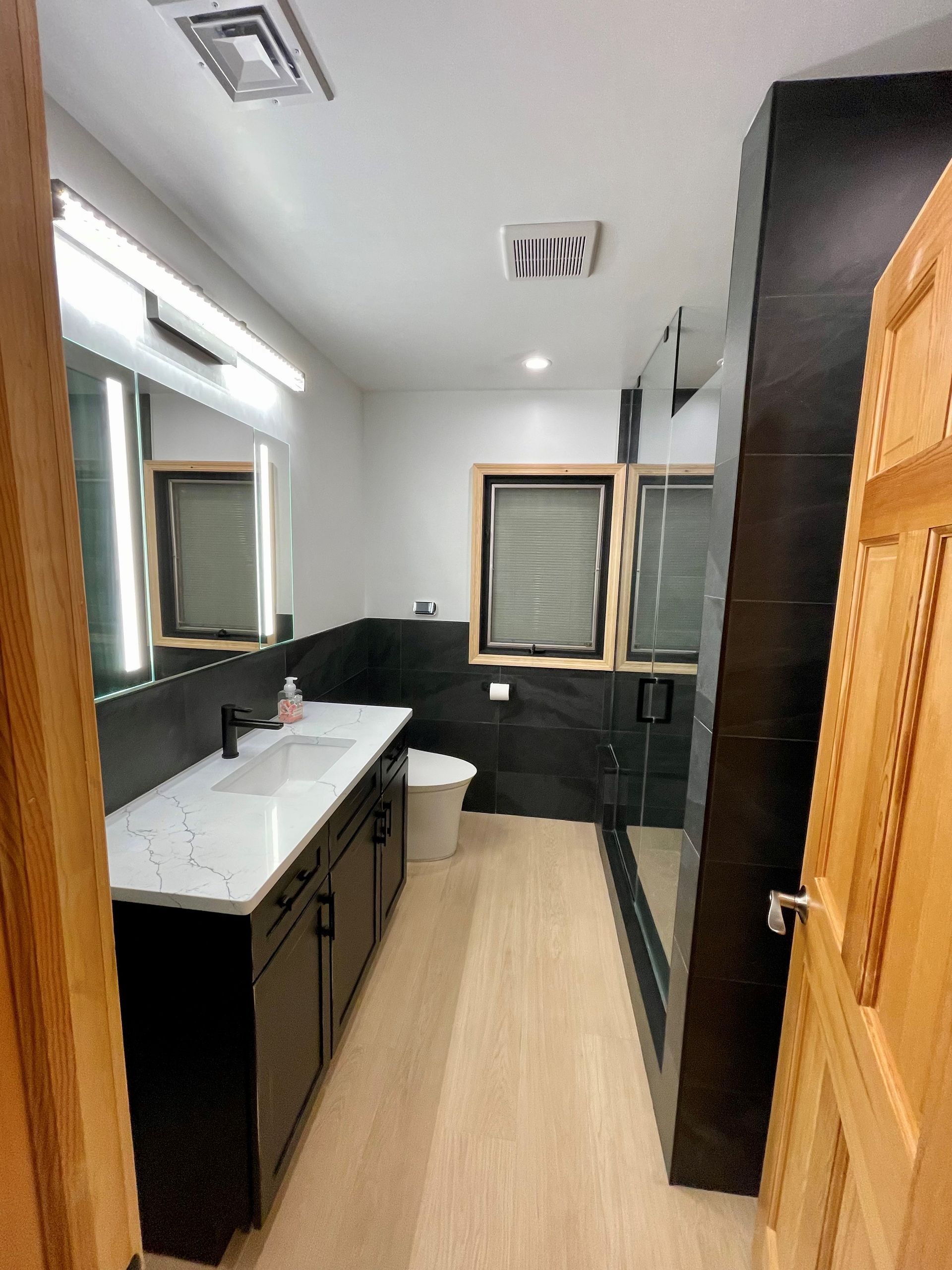 A bathroom with a toilet a sink and a mirror
