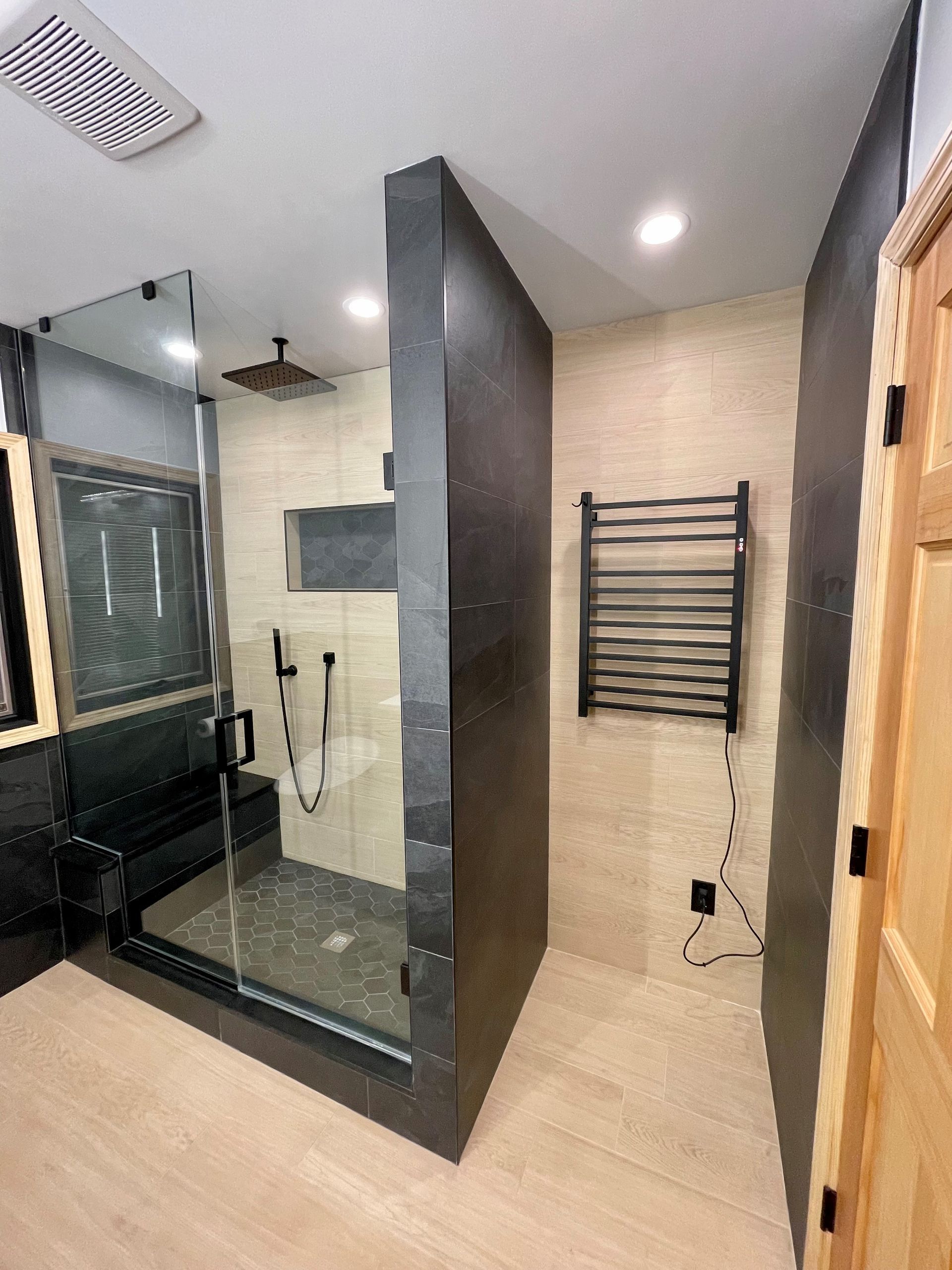 A bathroom with a walk in shower and a towel rack.