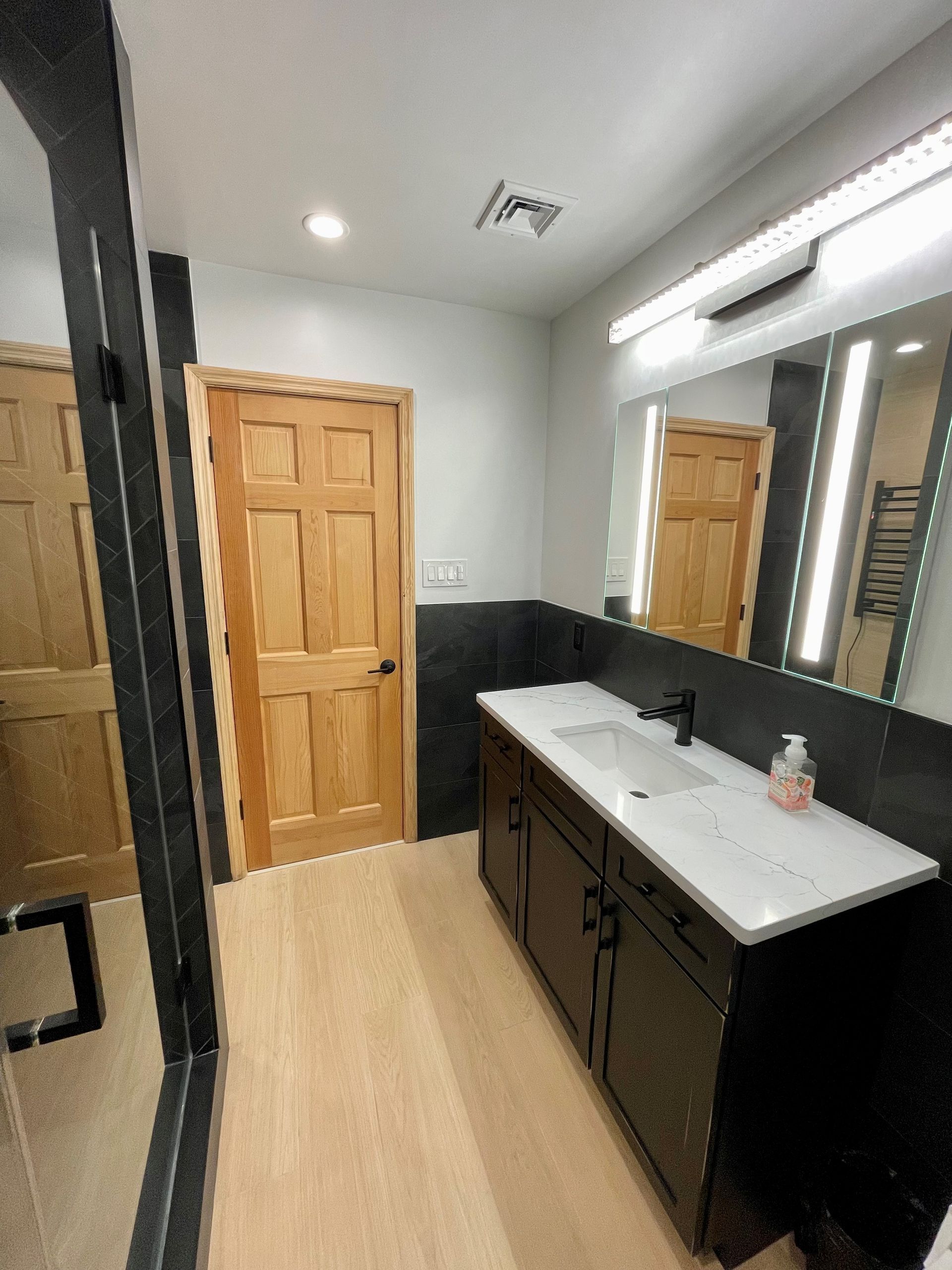 A bathroom with two sinks and a large mirror.
