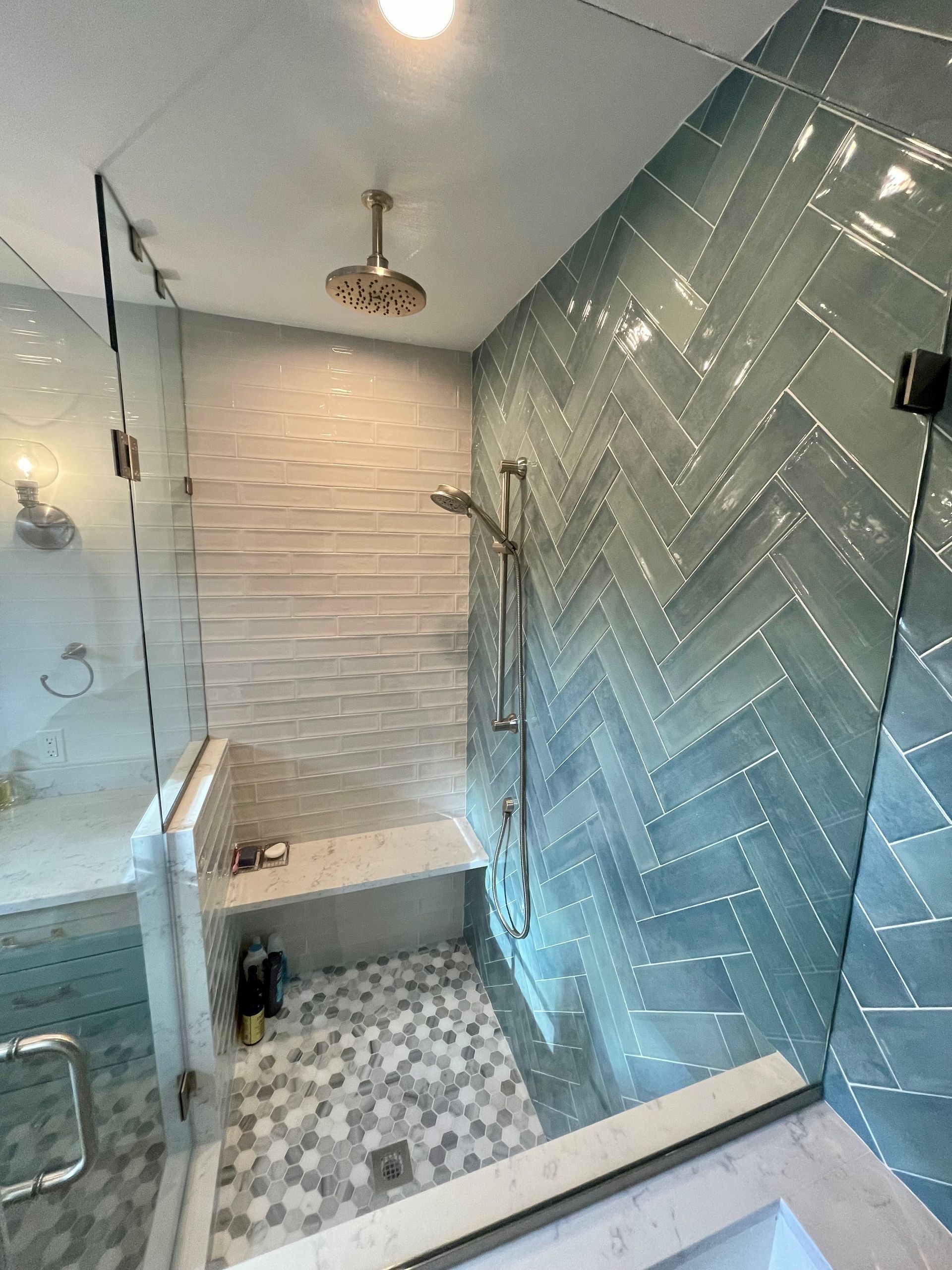 A bathroom with a walk in shower and a bench.