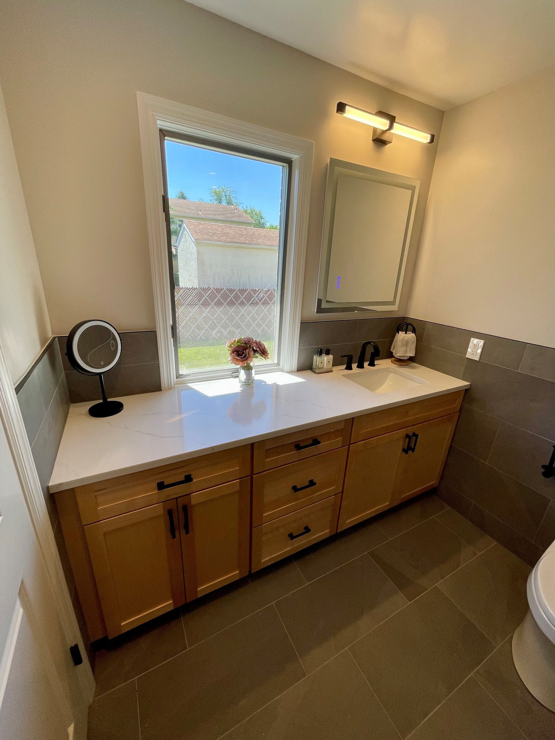 A bathroom with a sink, mirror, and toilet.