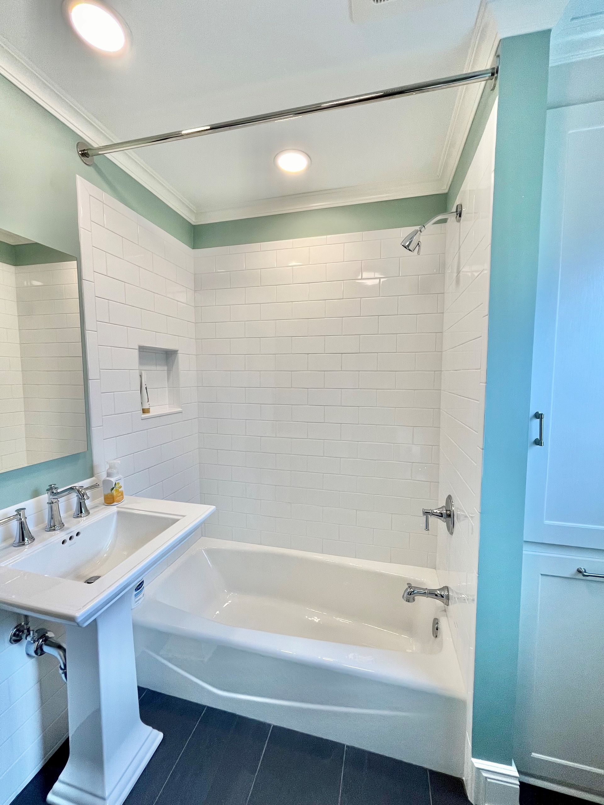 A bathroom with a sink, tub, shower and mirror.
