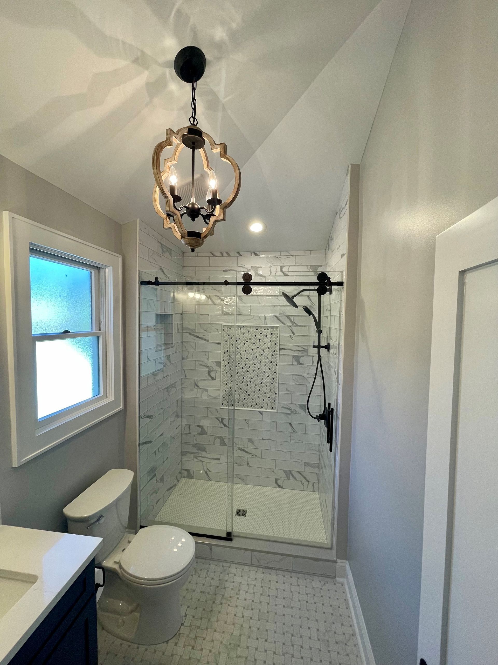 A bathroom with a toilet, sink, and shower.