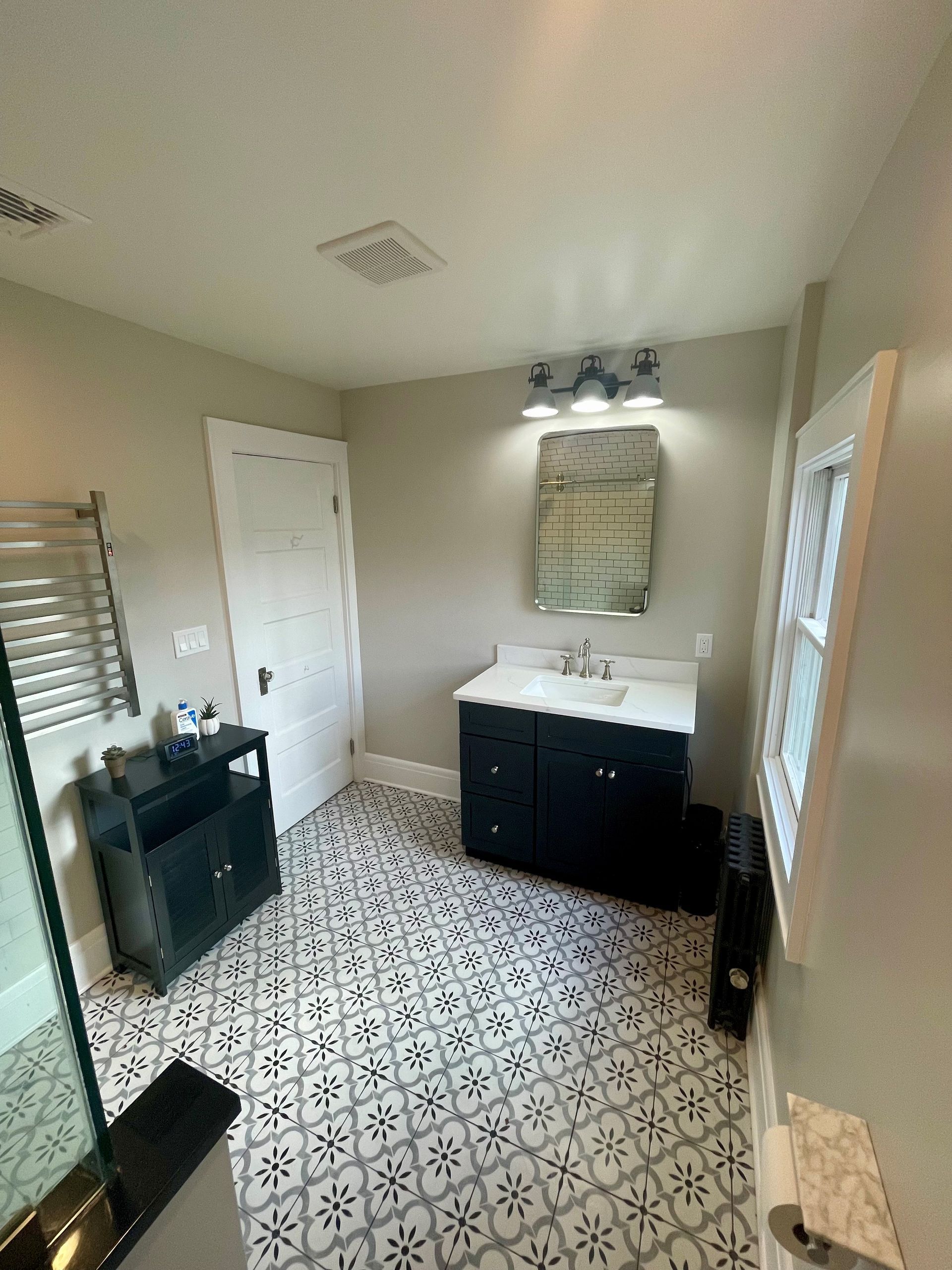 A bathroom with a sink, mirror, and tile floor.