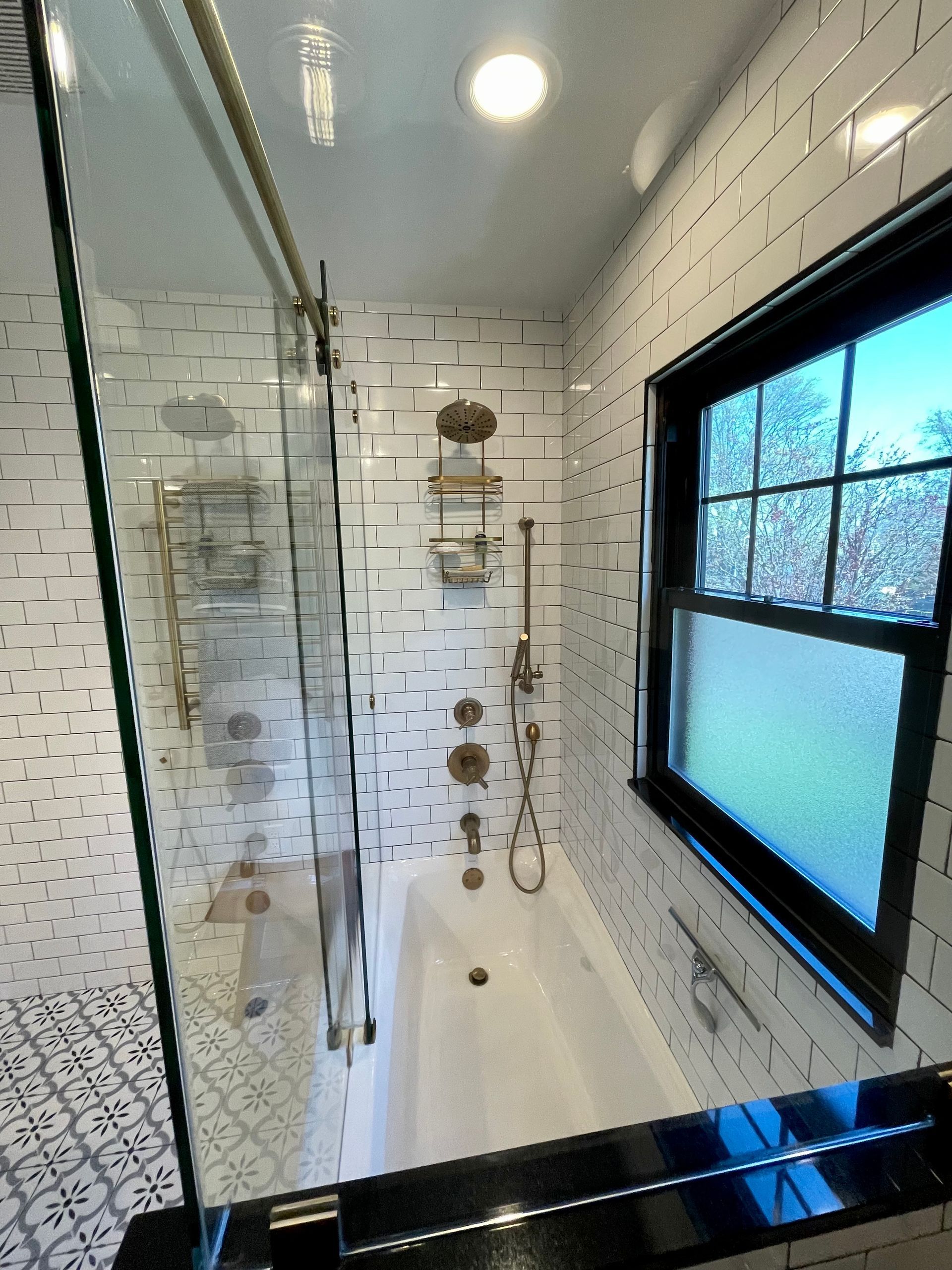 A bathroom with a tub, shower, and window