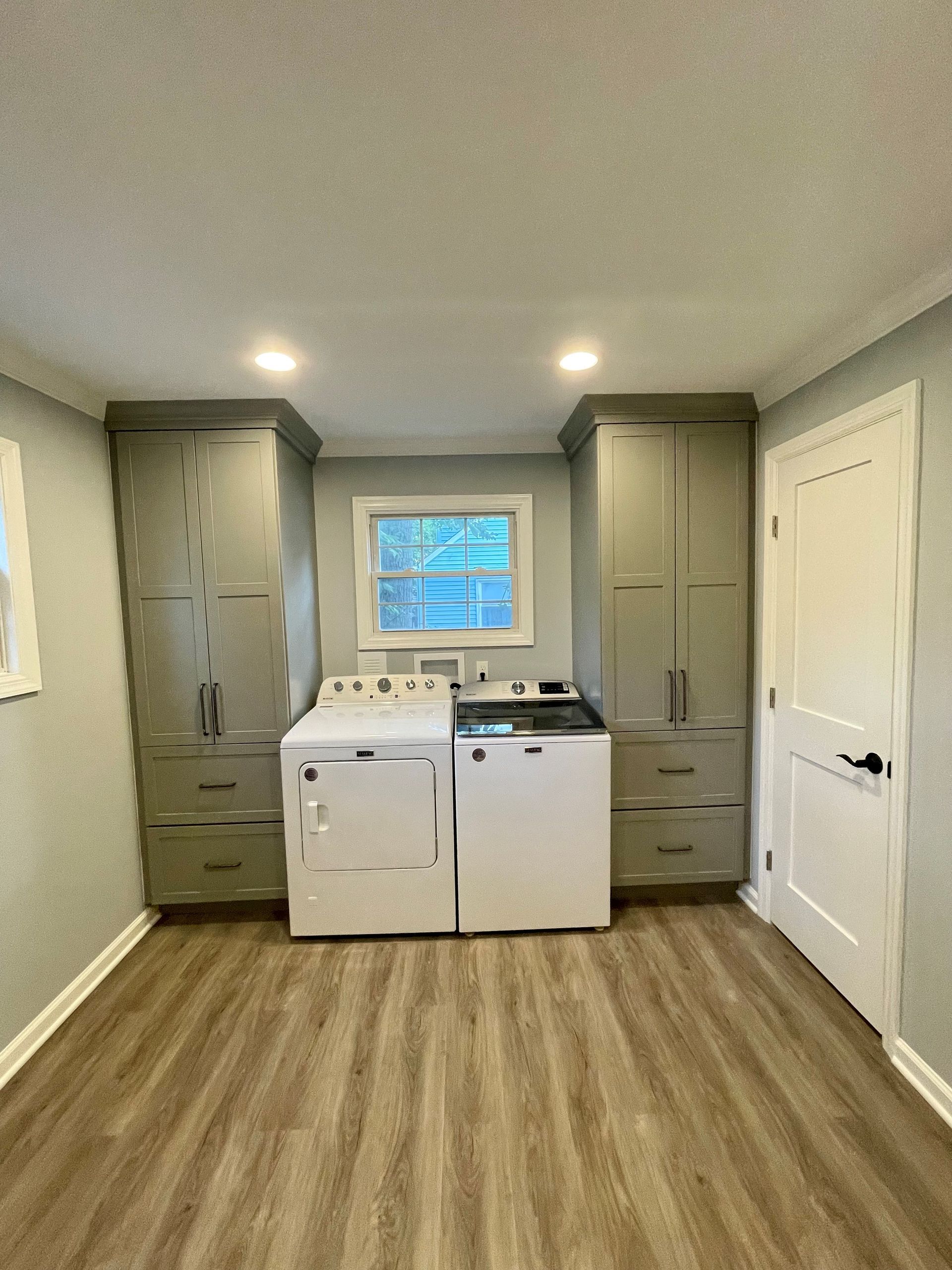 A laundry room with a washer and dryer and a window.