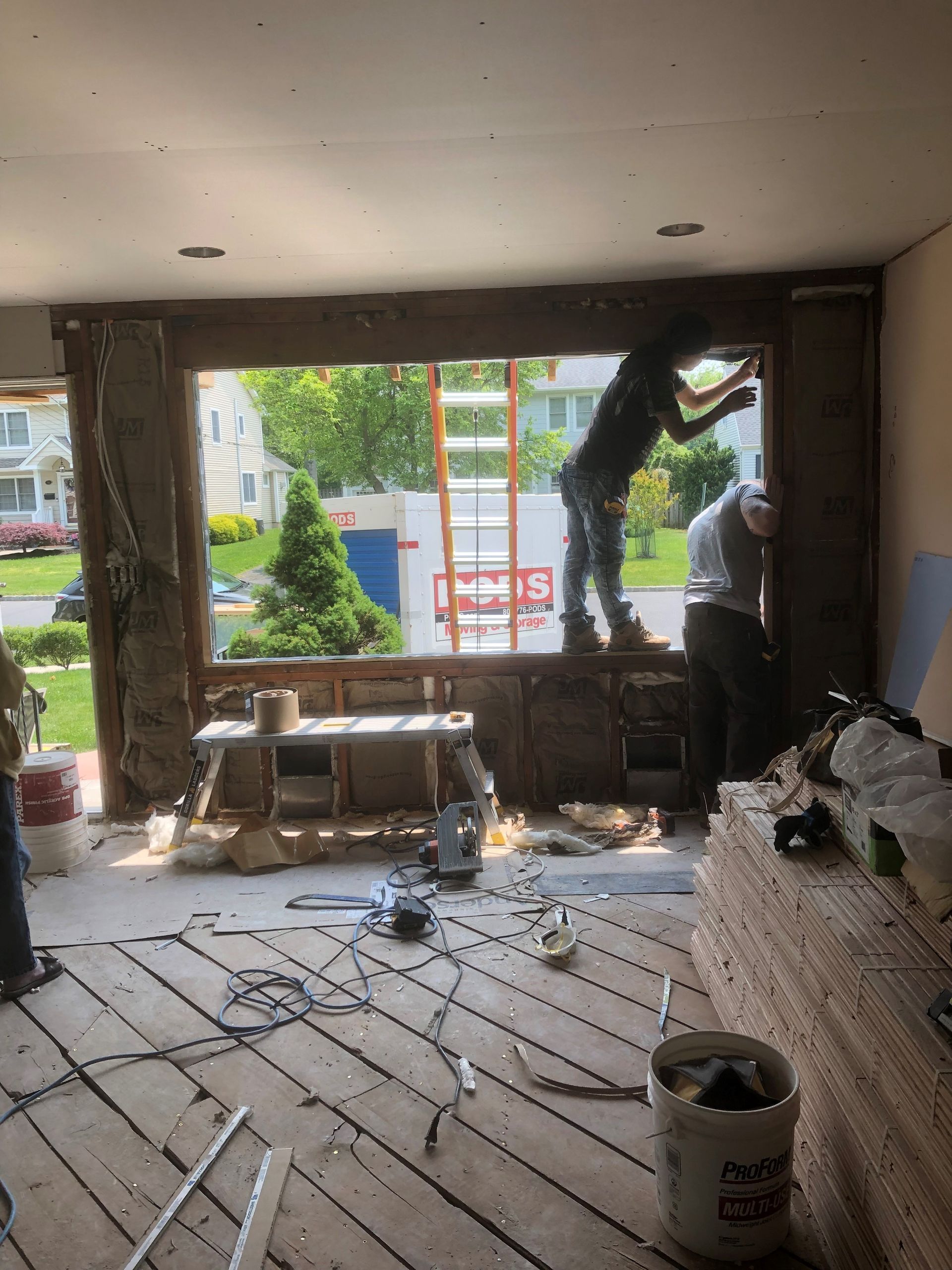 A group of people are working on a window in a room.