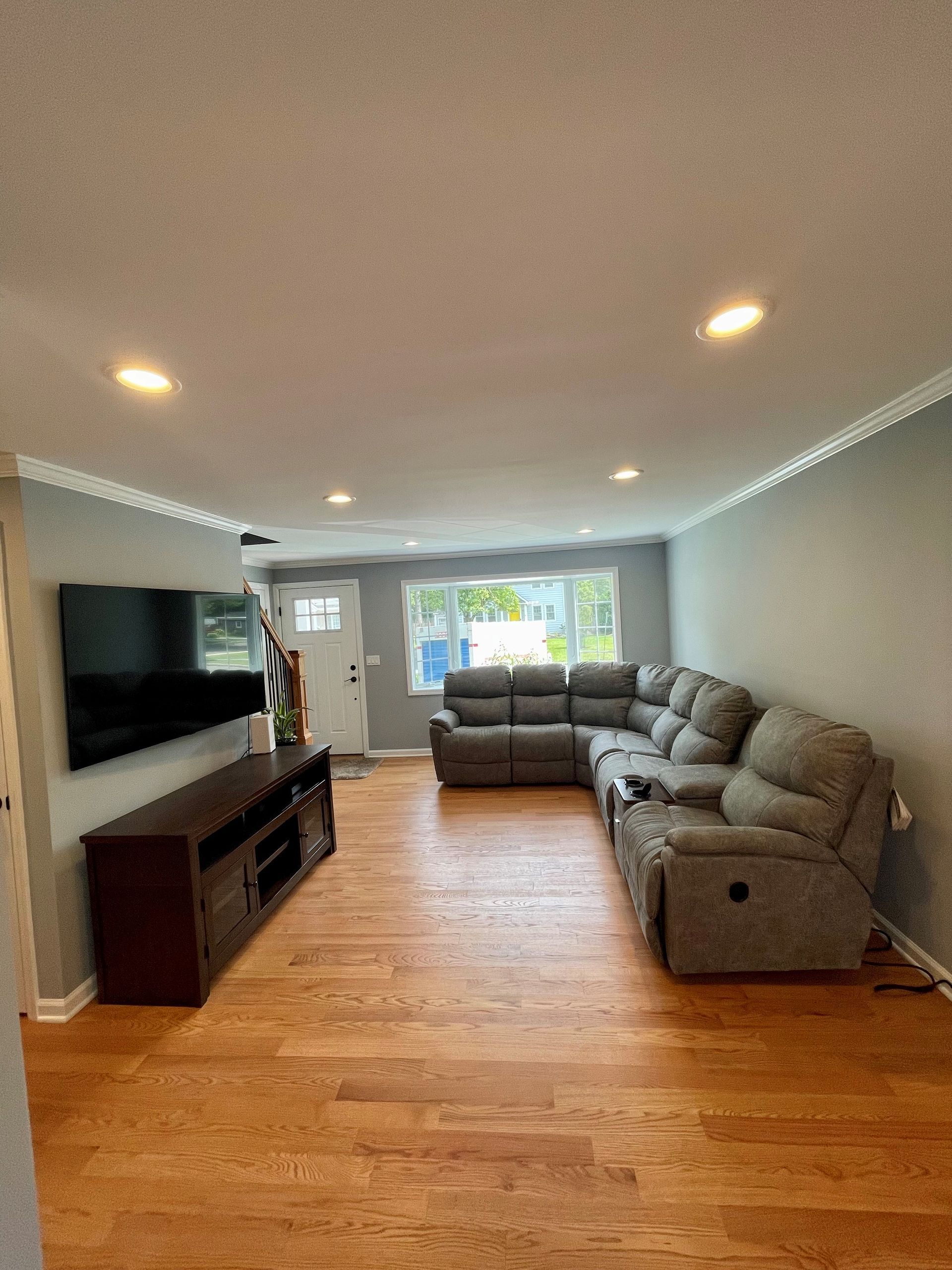 A living room with a large sectional couch and a flat screen tv.