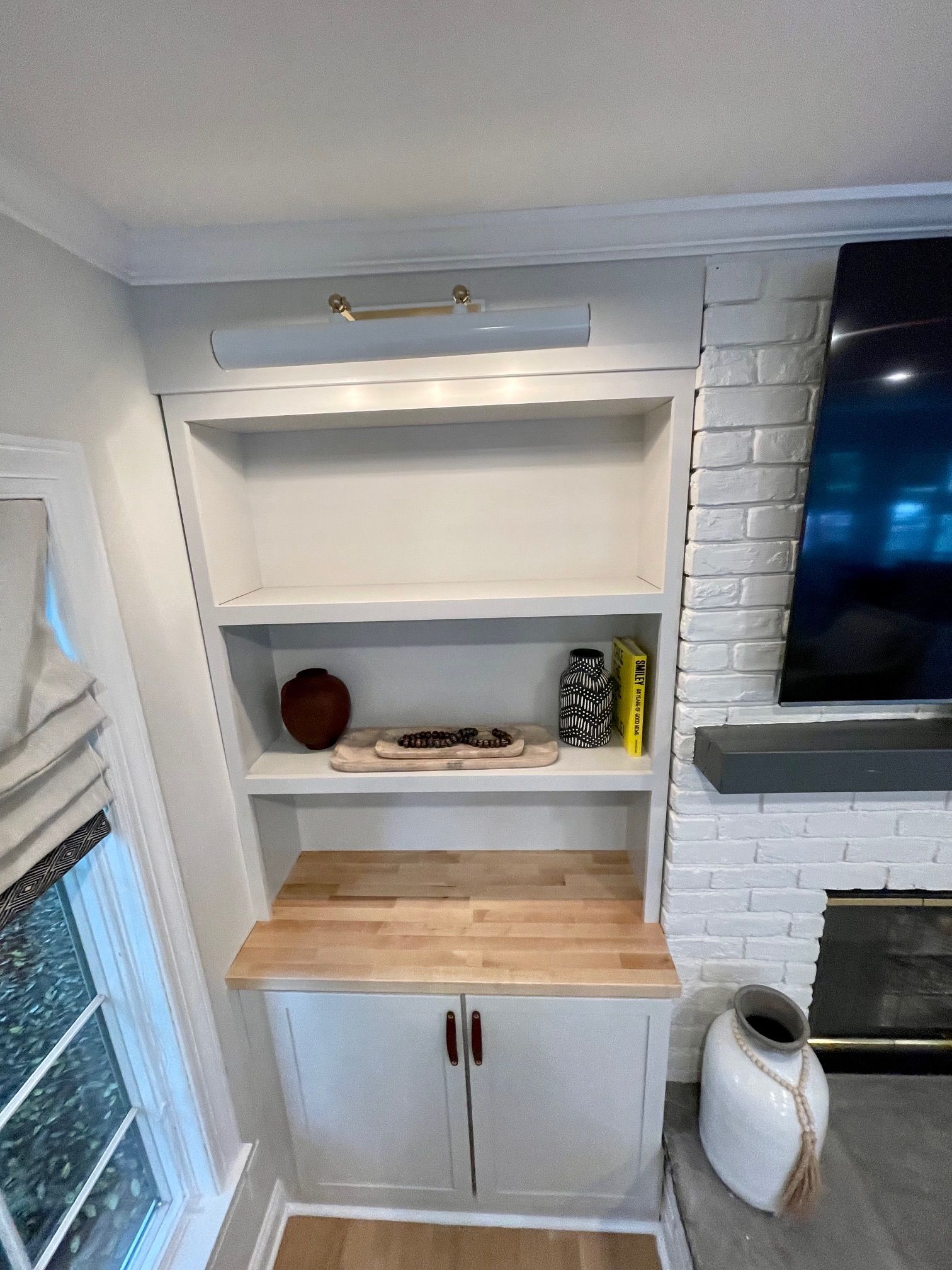A living room with a bookshelf and a fireplace.