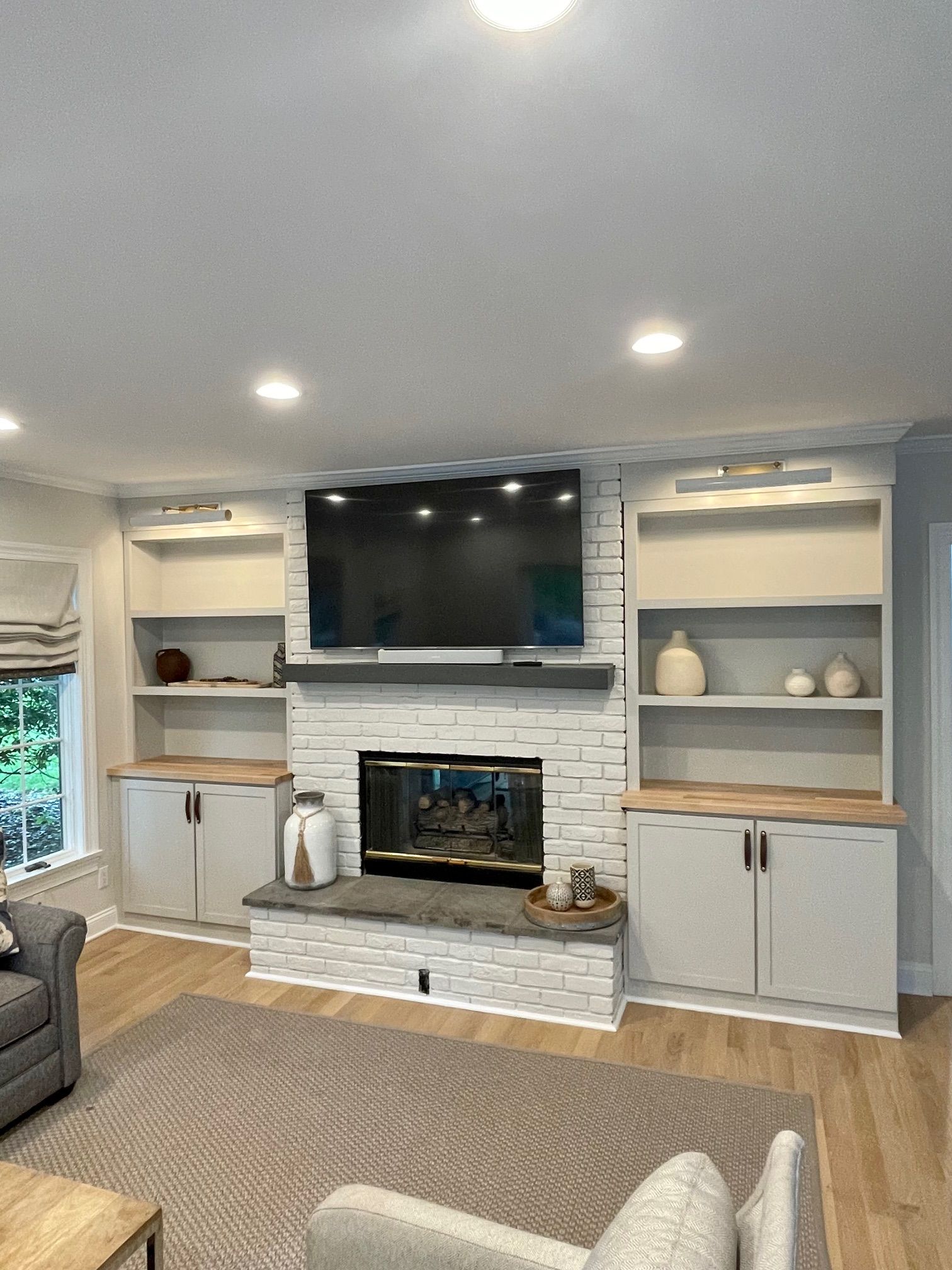 A living room with a fireplace and a flat-screen TV.