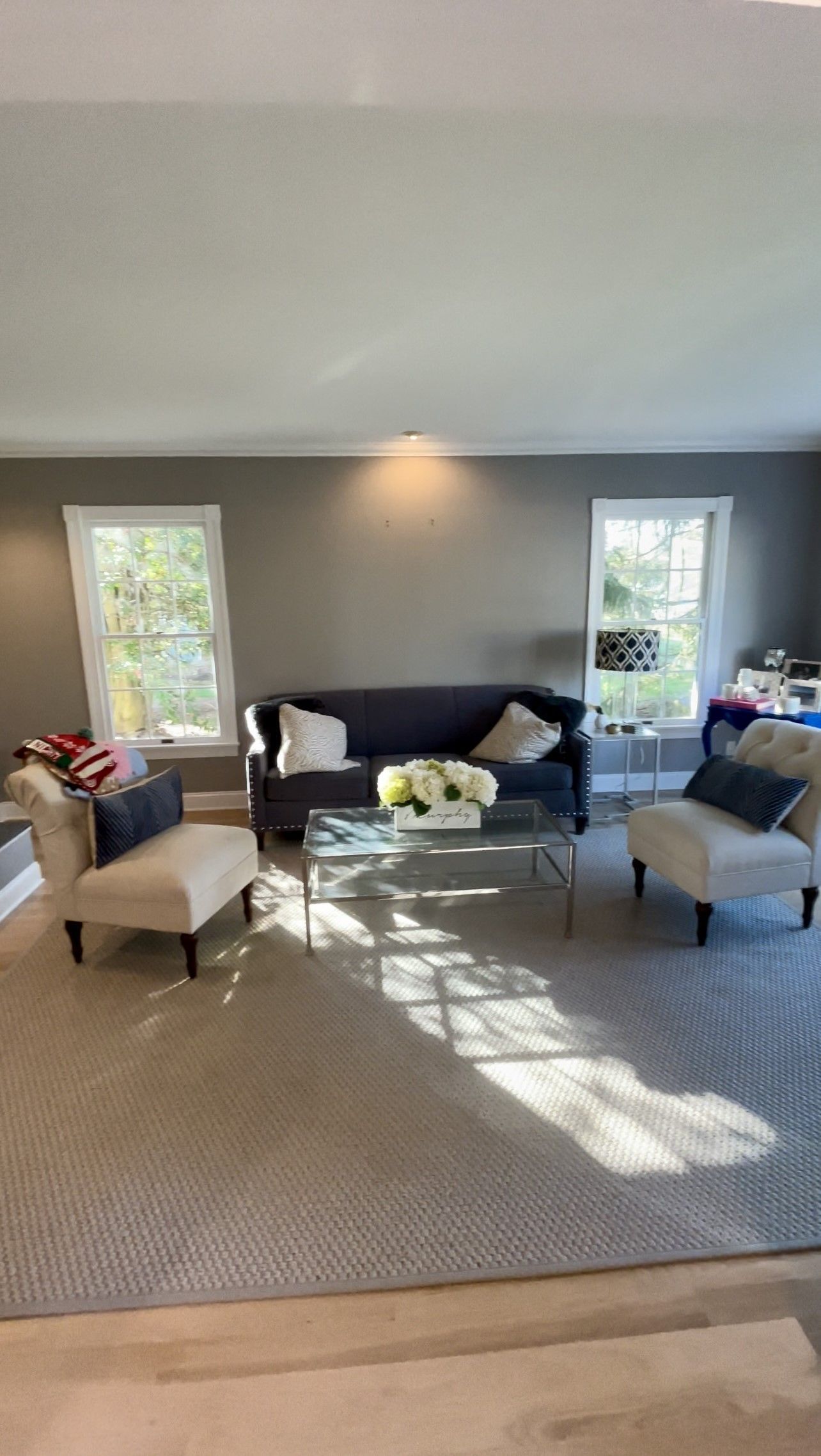 A living room with a couch, chairs, coffee table, and rug.