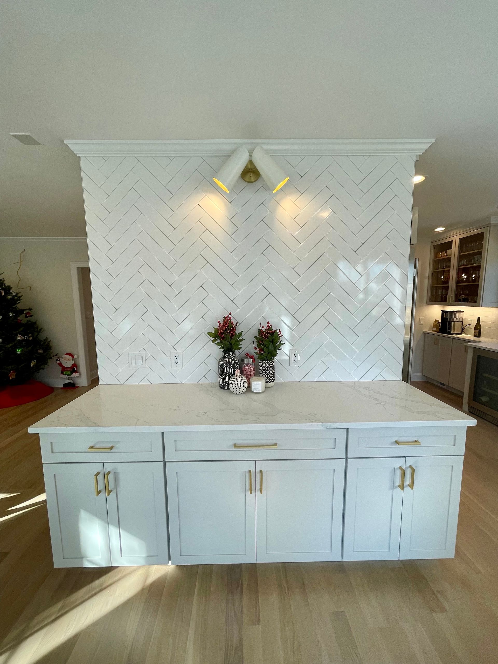 A kitchen with white cabinets and a christmas tree in the background