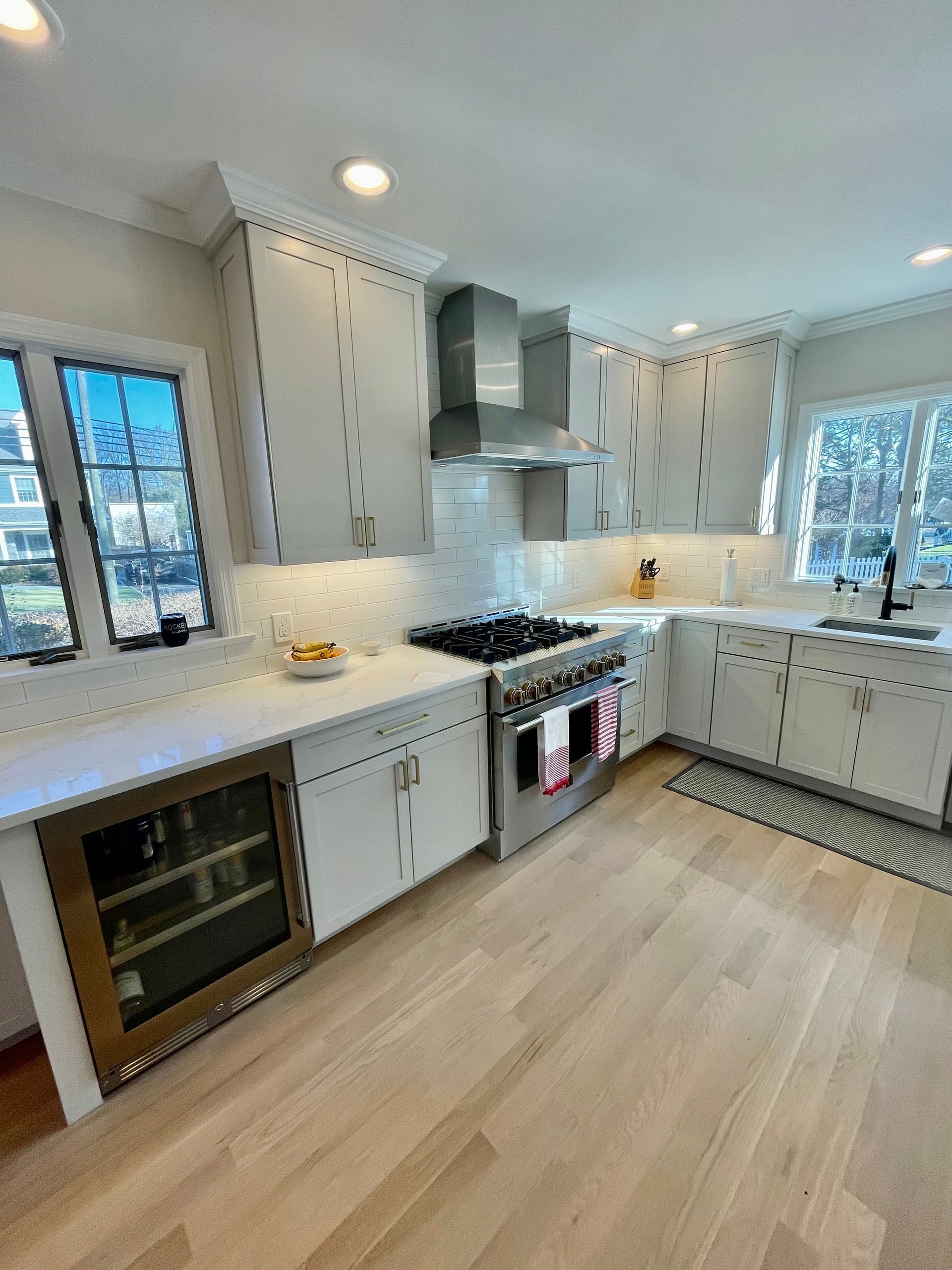 A kitchen with white cabinets, stainless steel appliances, a refrigerator, and a stove.