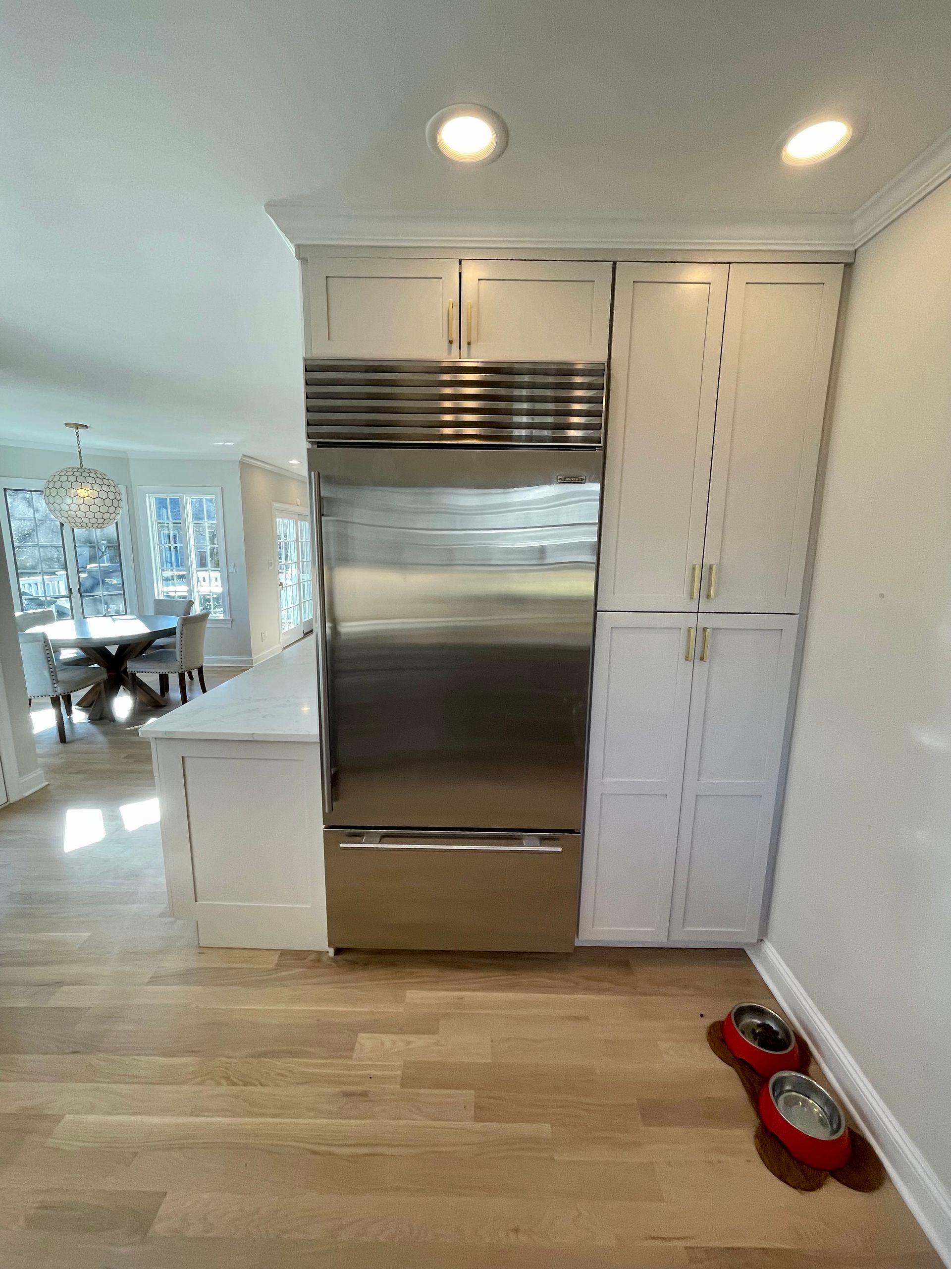 A kitchen with stainless steel appliances and white cabinets.