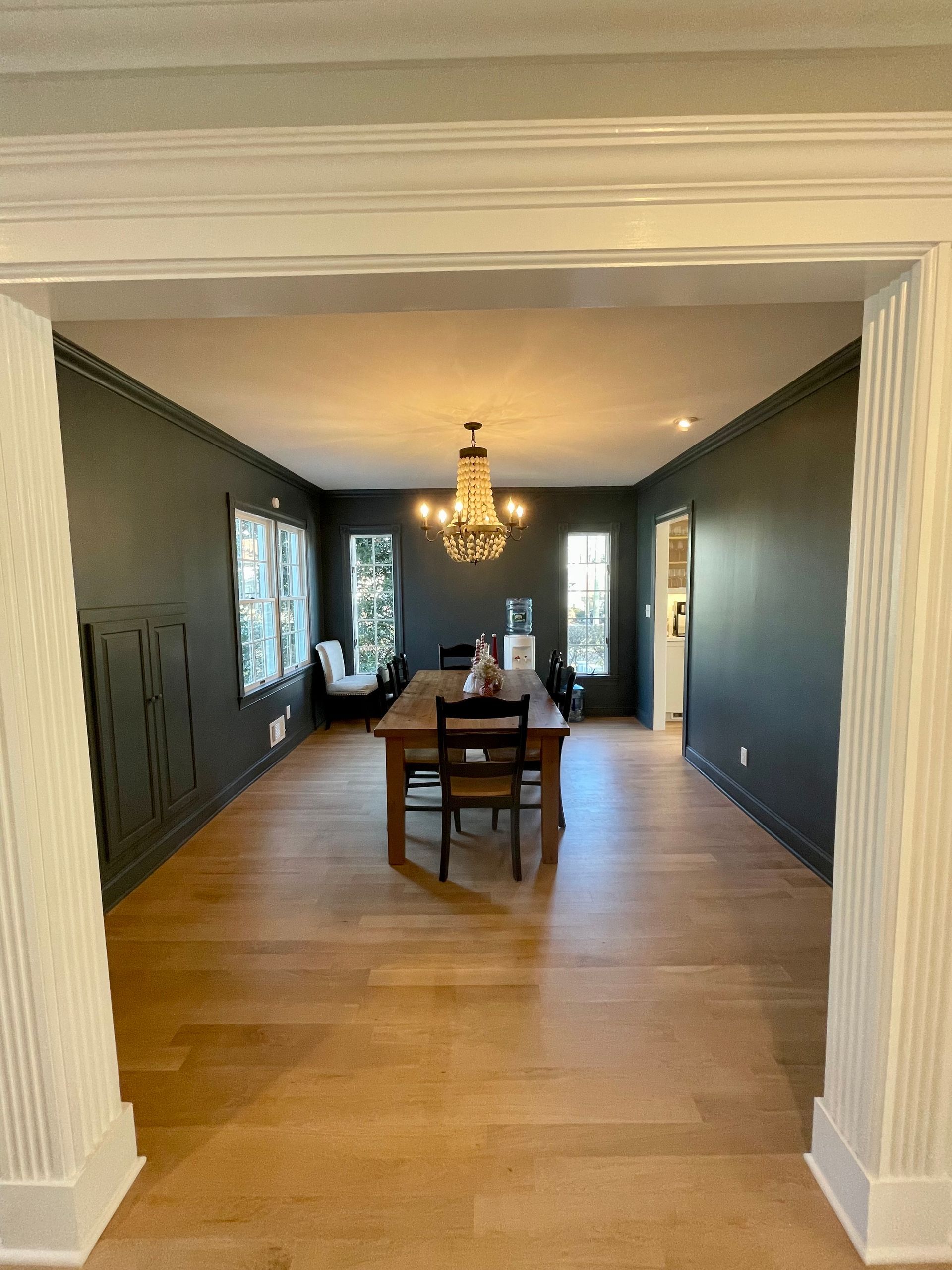 A large dining room with a wooden table and chairs and a chandelier.