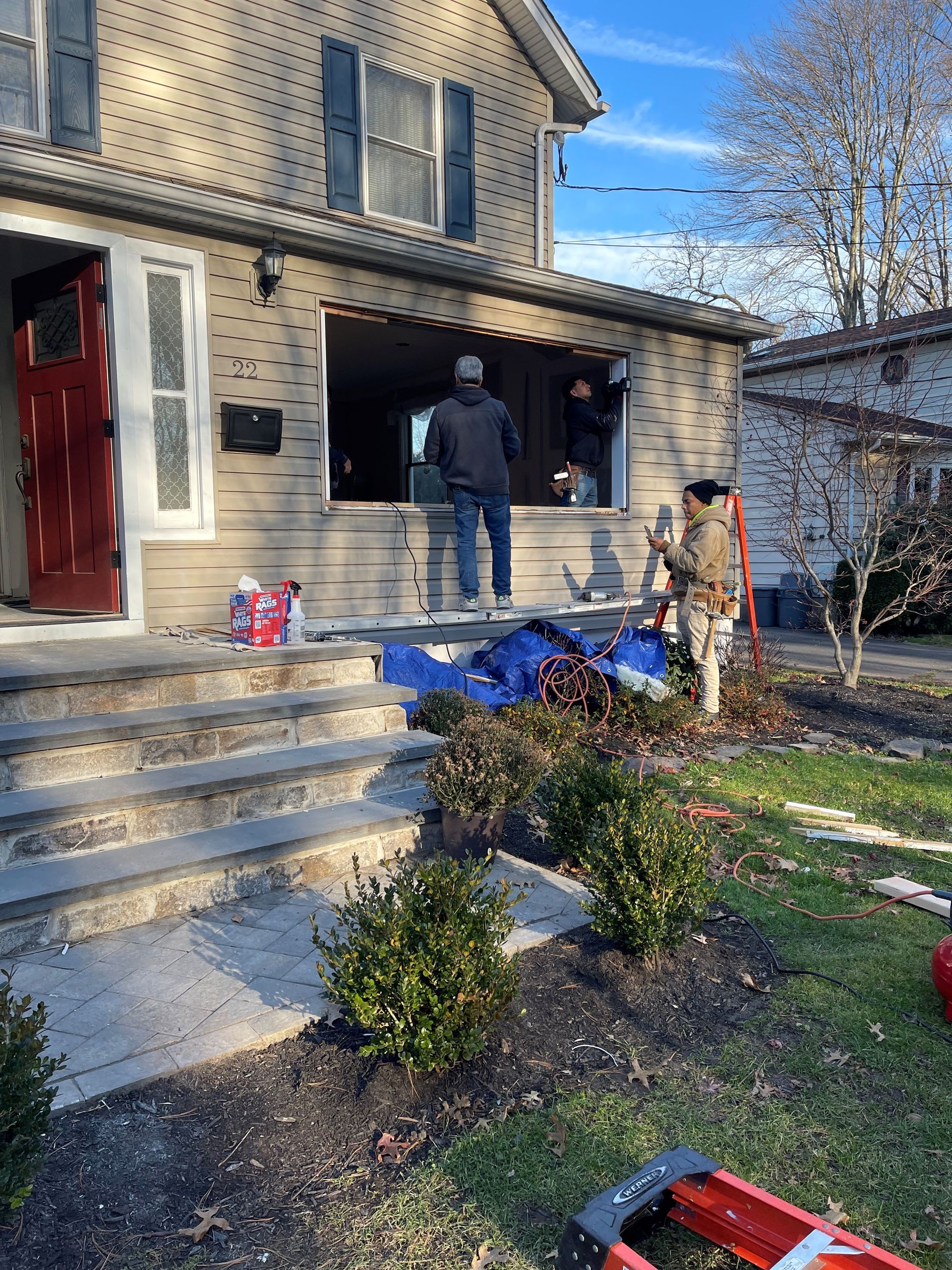 A man is standing on the porch of a house.