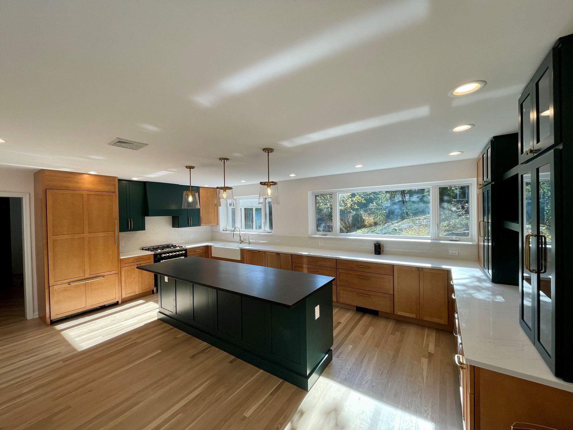 A kitchen with wooden cabinets and a large island in the middle.