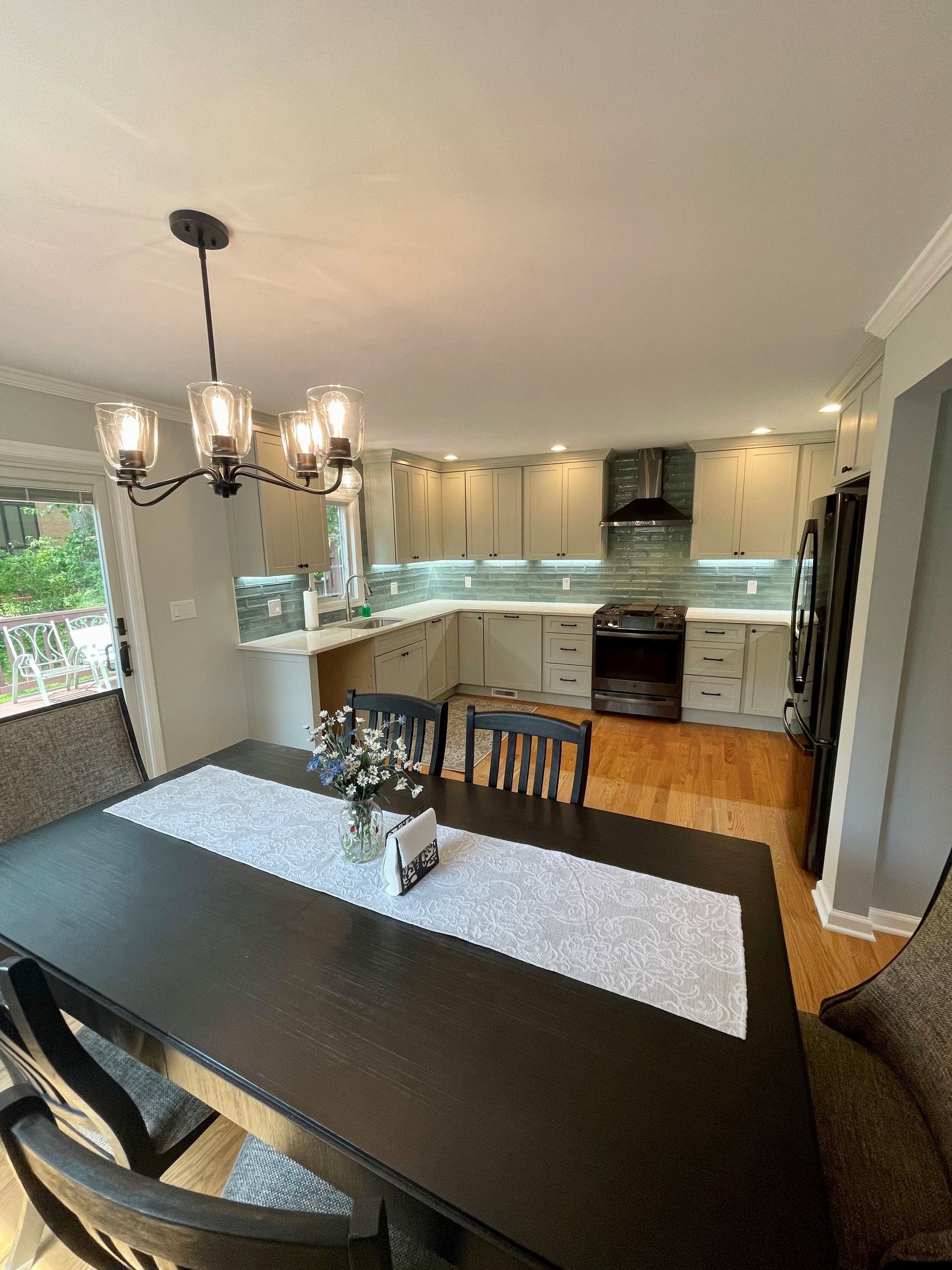 A kitchen with a dining table and chairs and a chandelier.