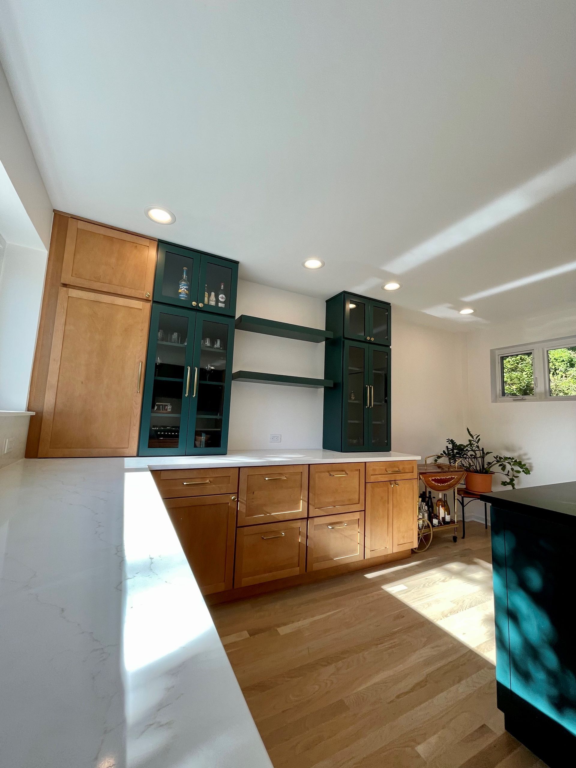 A kitchen with wooden cabinets and green cabinets