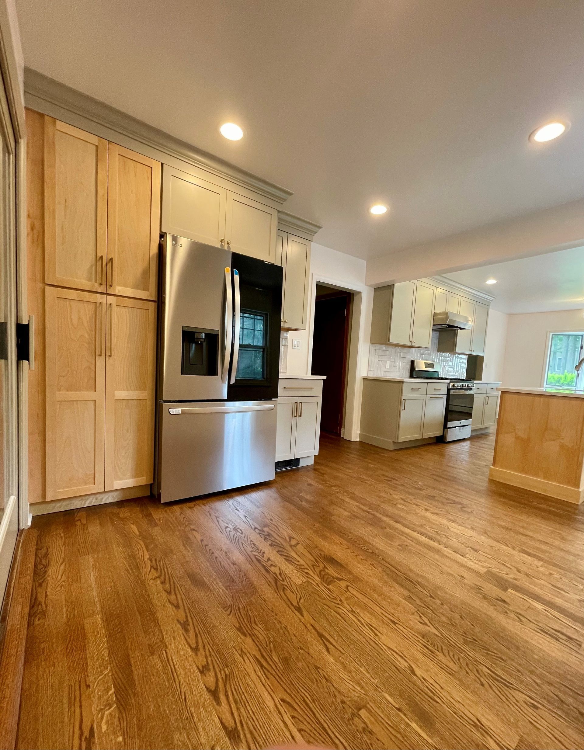 A kitchen with hardwood floors and stainless steel appliances