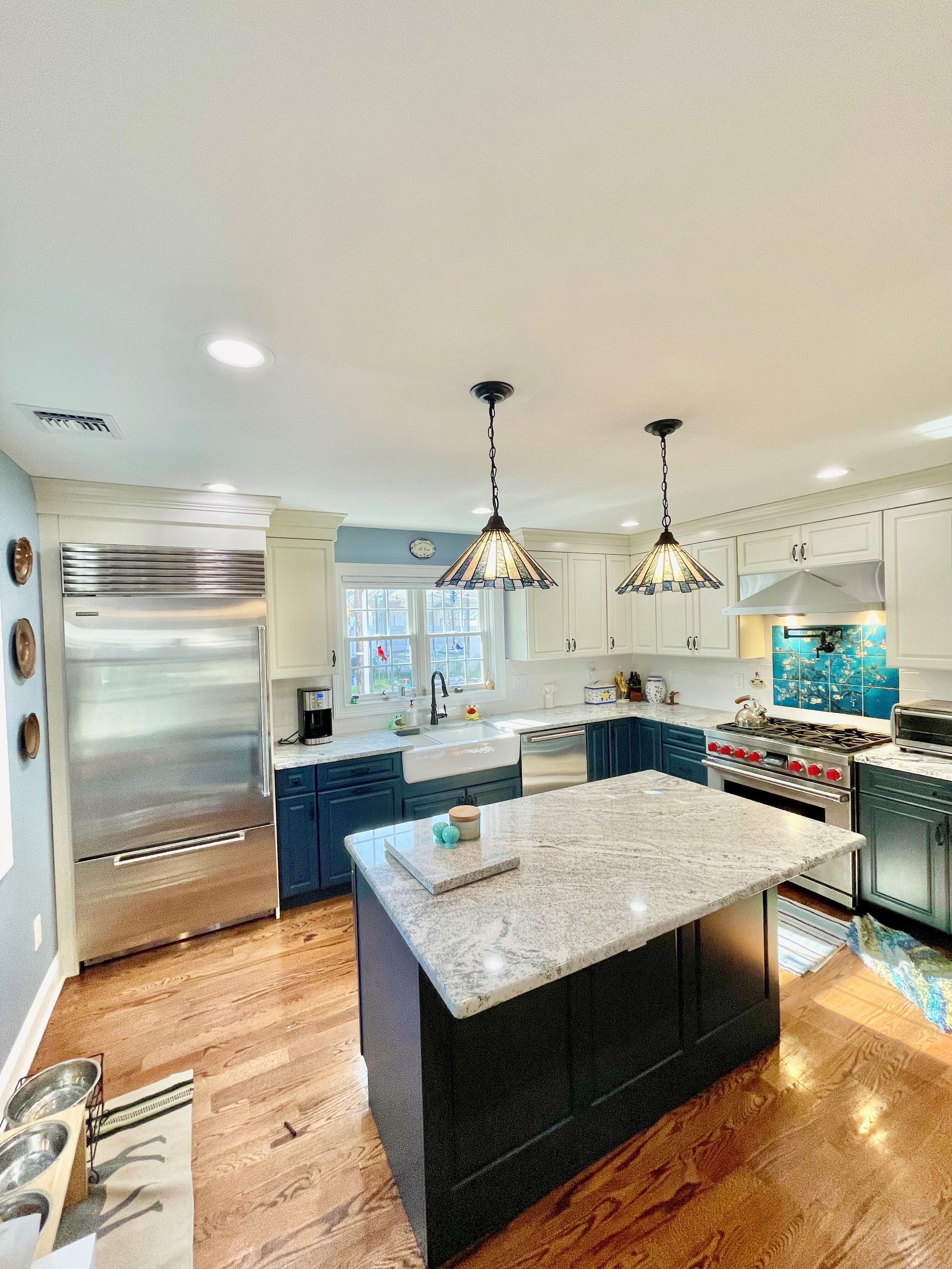 A kitchen with stainless steel appliances and a large island in the middle.