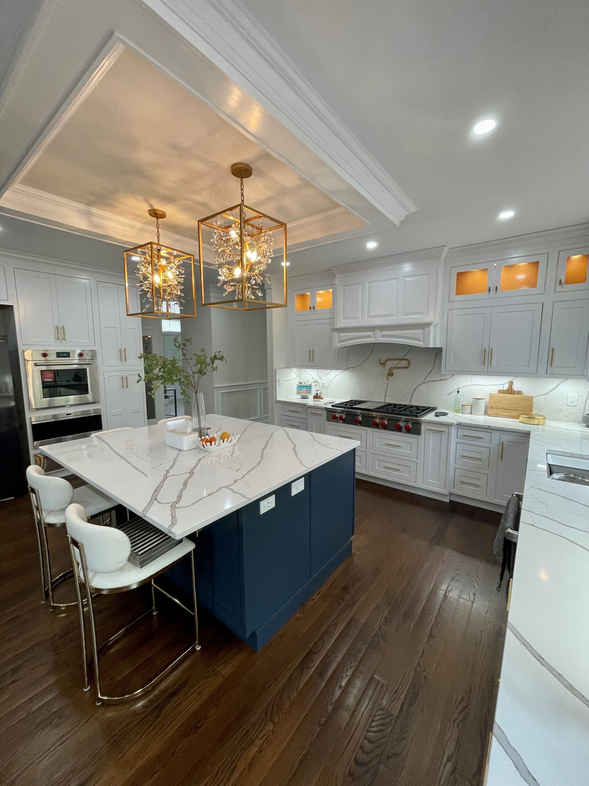 A kitchen with white cabinets and a large island in the middle.