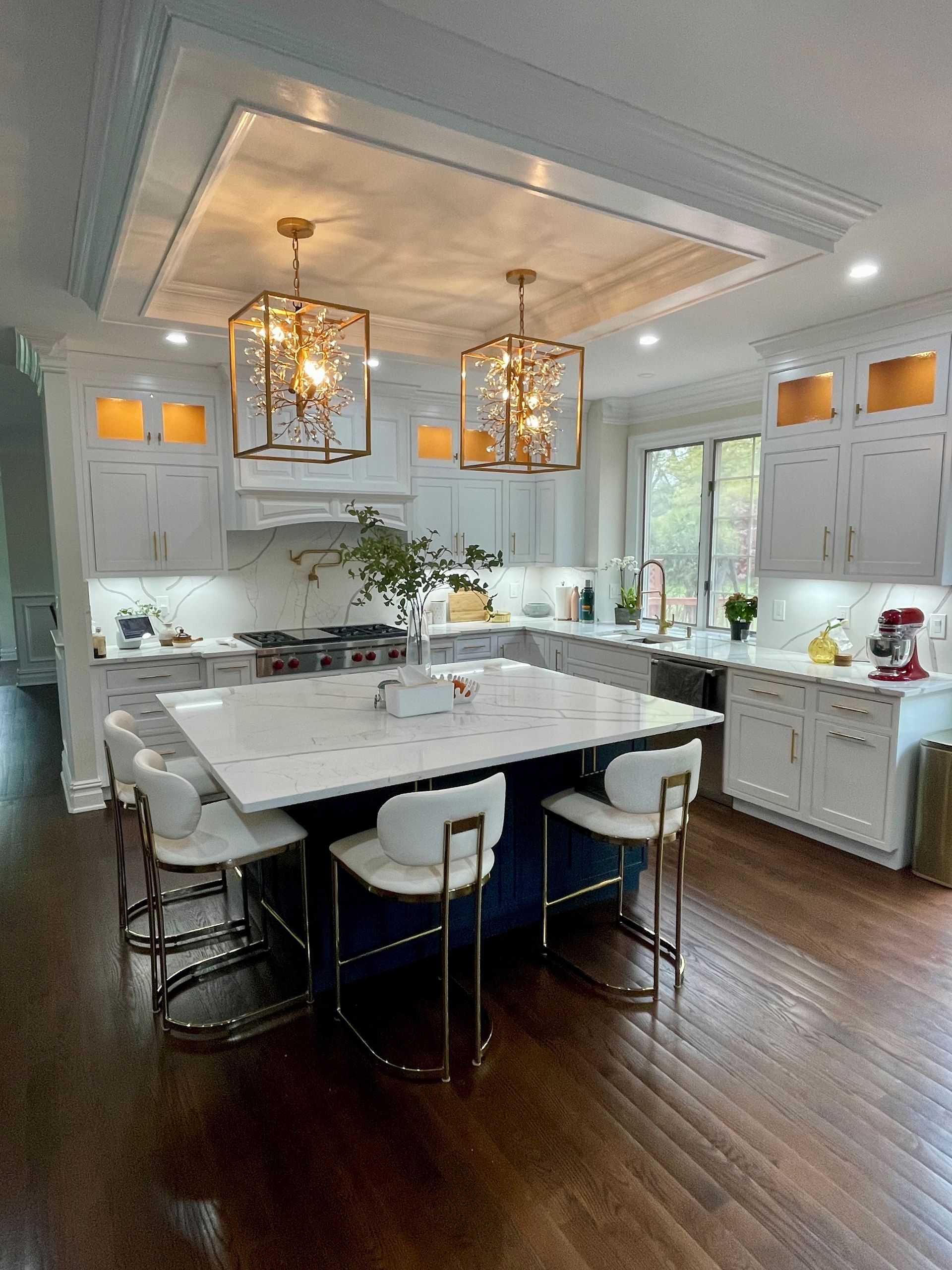 An image of a kitchen with white cabinets and a large island in the middle.