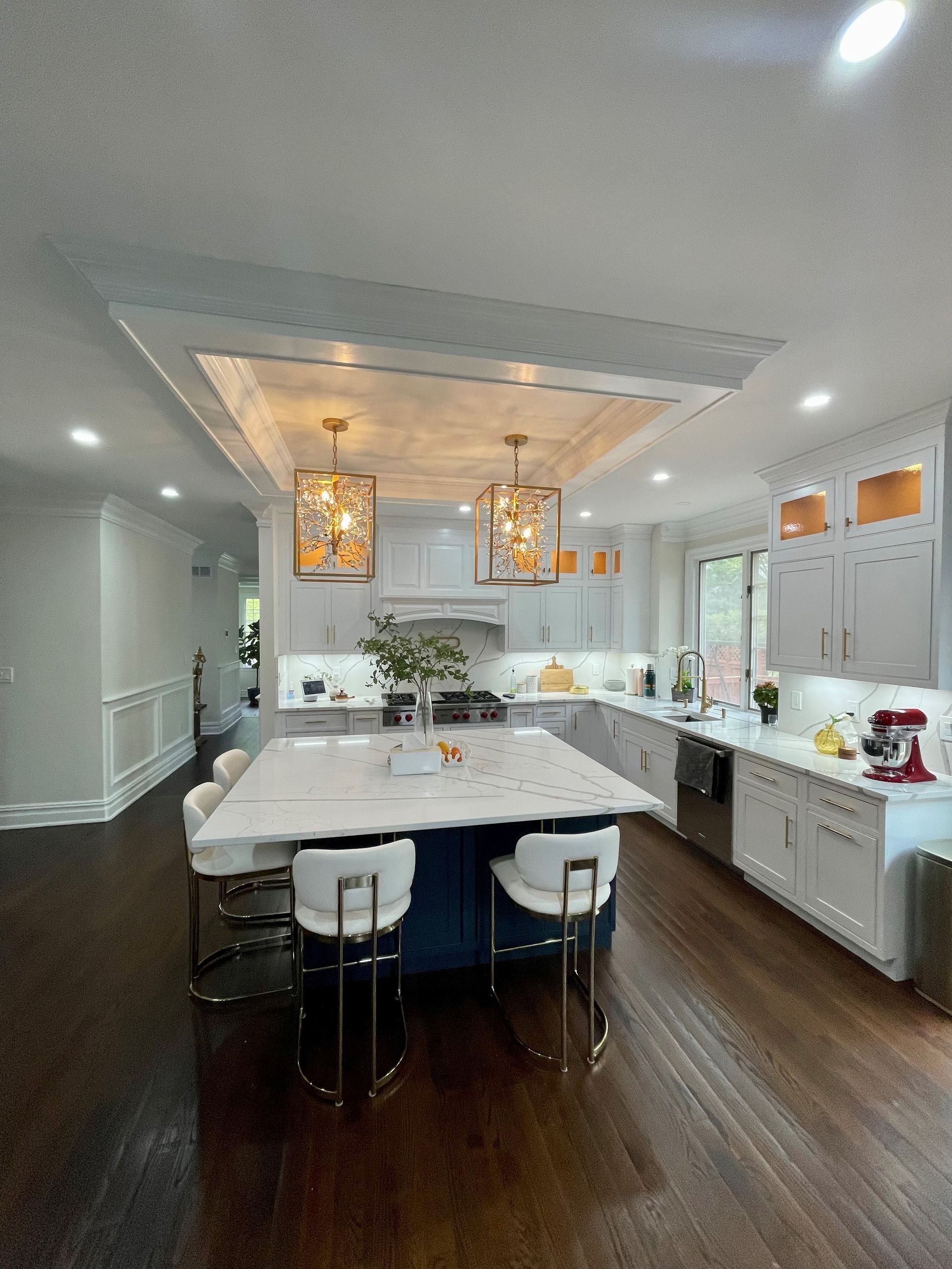 A kitchen with a large island in the middle and white cabinets.