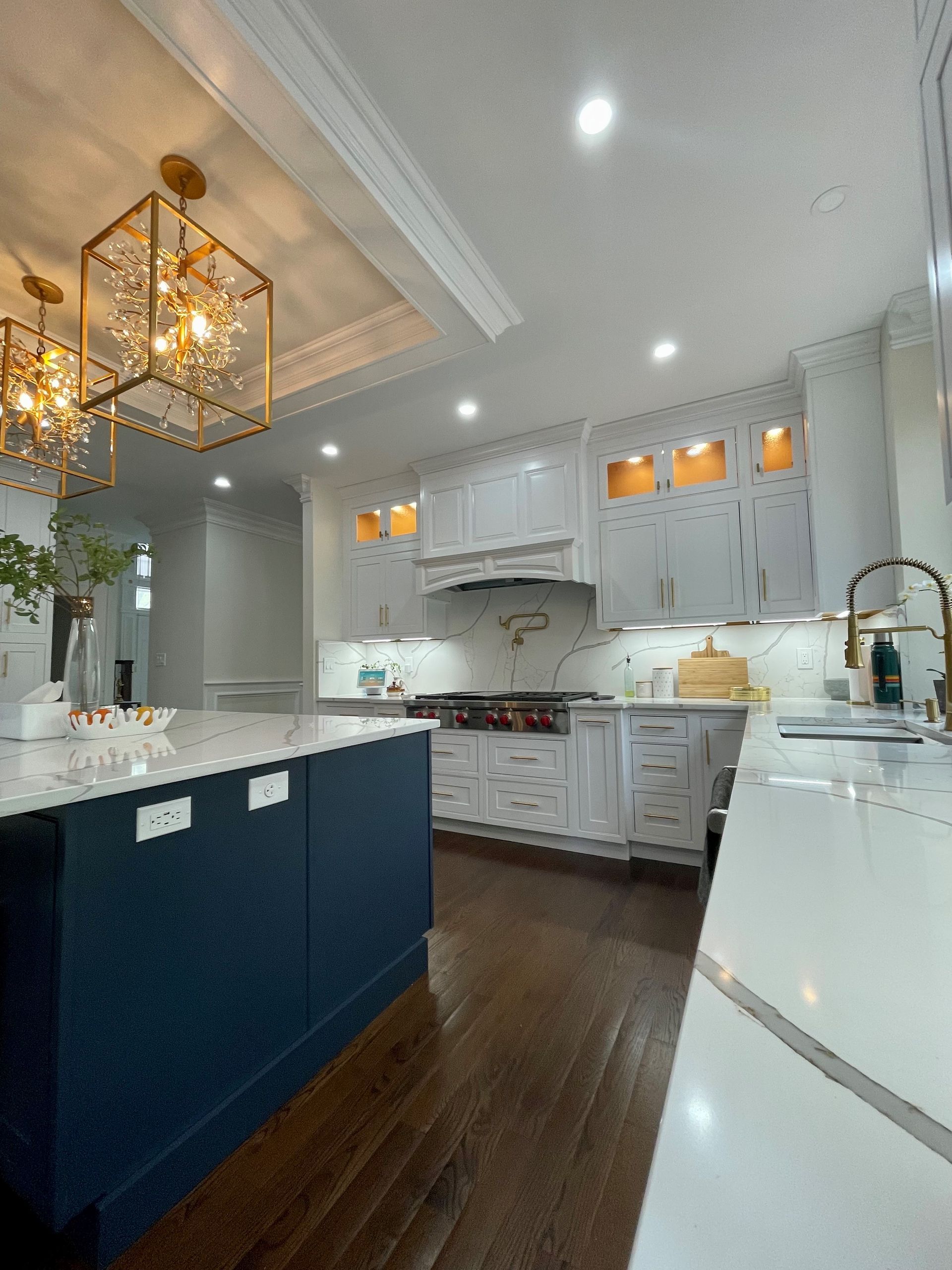 A kitchen with white cabinets and a blue island.