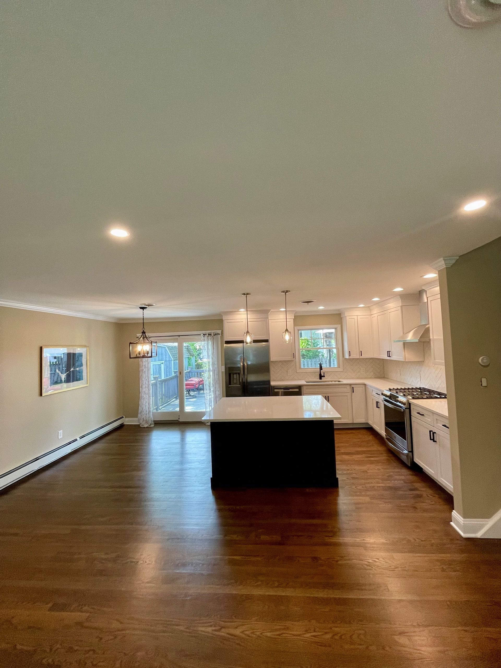 A kitchen with stainless steel appliances and a large island in the middle of the room.