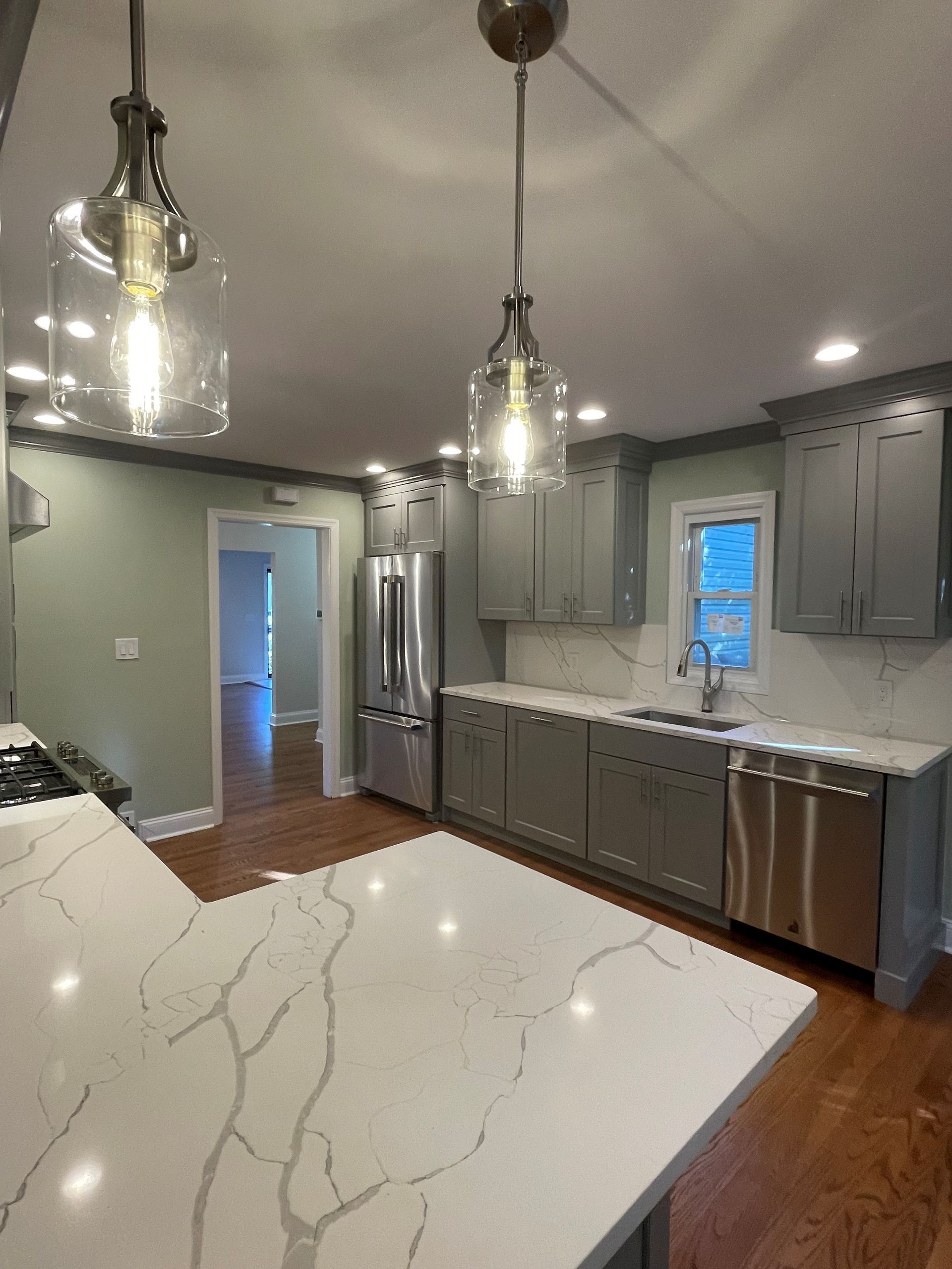 A kitchen with stainless steel appliances and white counter tops