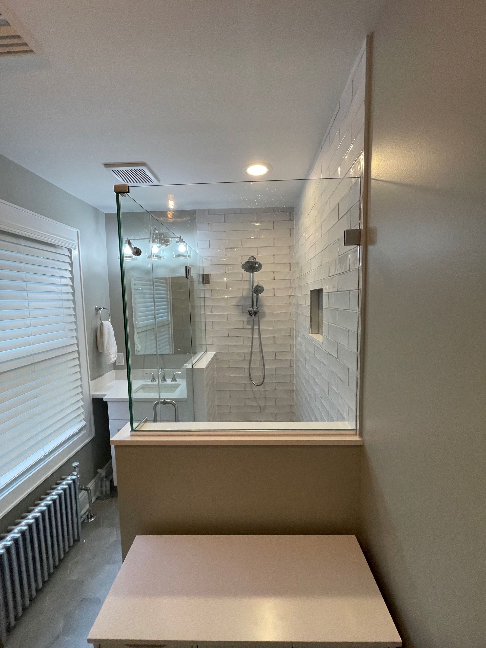 A bathroom with a walk in shower and a sink.