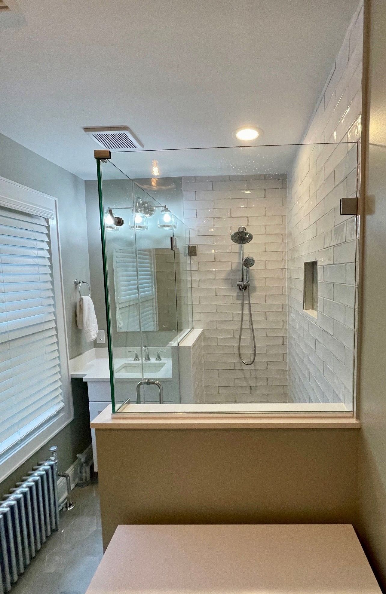 A bathroom with a walk in shower and a sink.