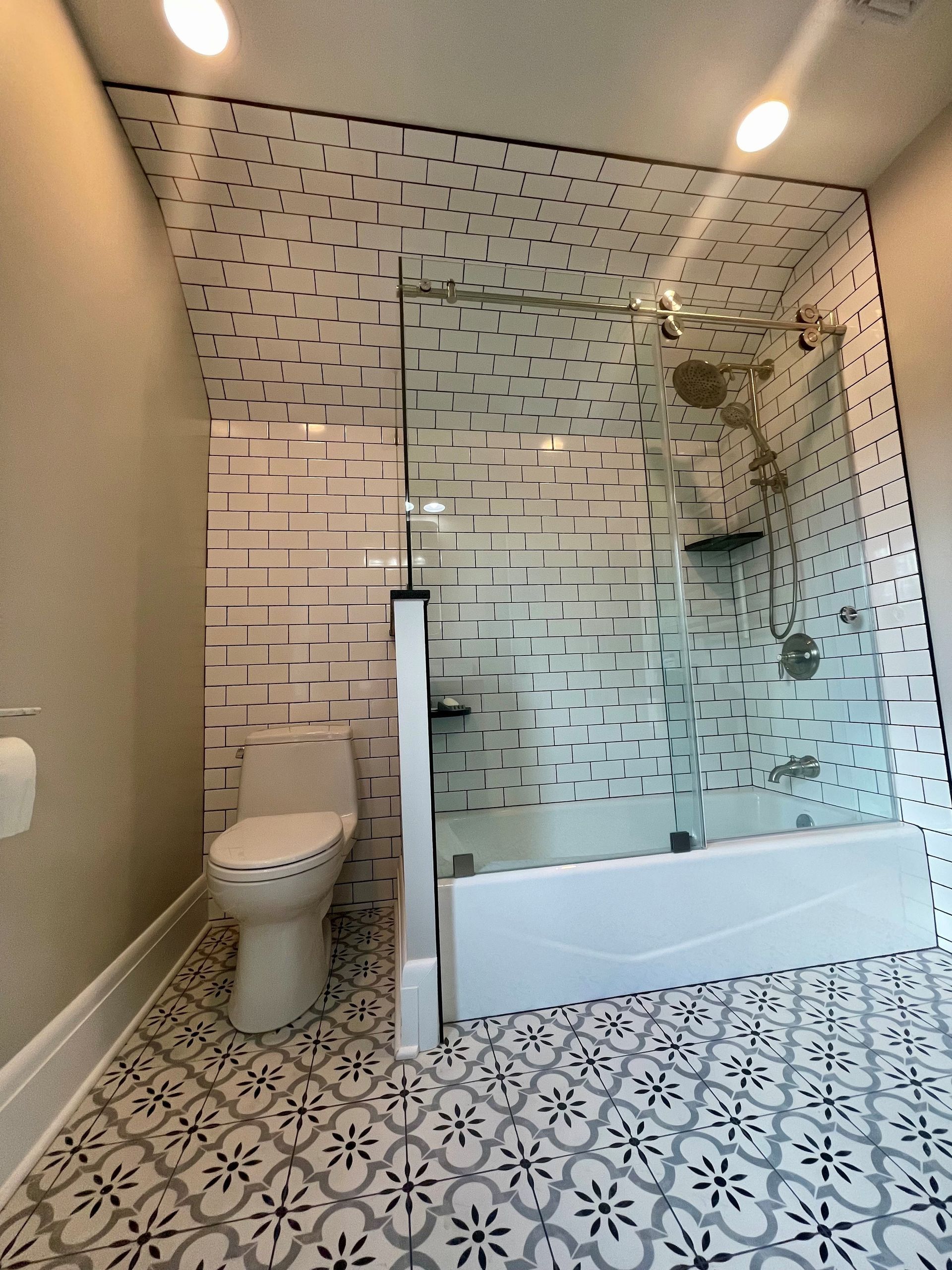 A bathroom with a toilet a bathtub and a shower.